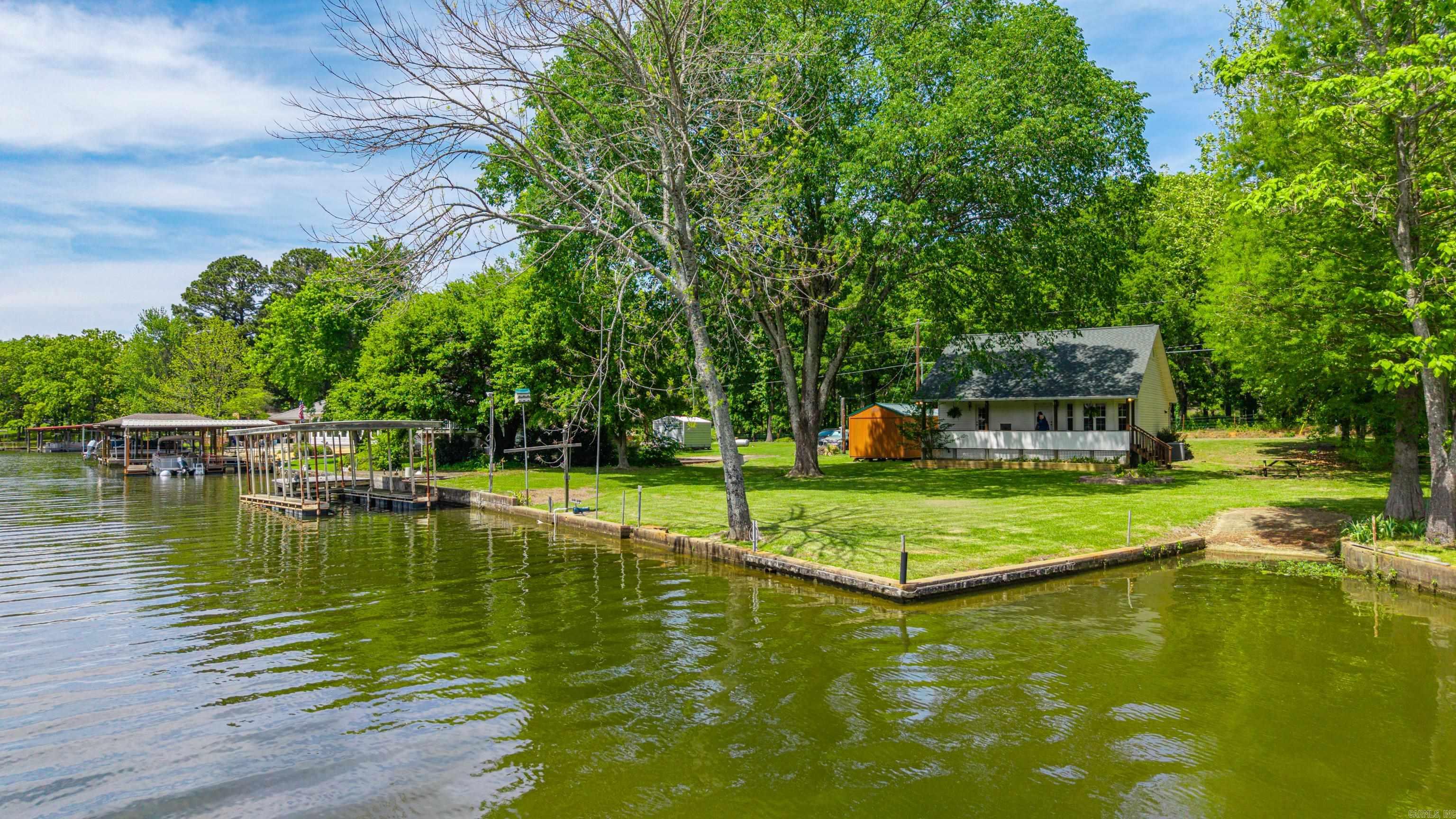 A picture-perfect lakefront cabin that checks every box and then some. Sitting pretty on a rare, flat double lot totaling .48 acres, this beauty boasts 109 feet of shoreline, your own private boat ramp, and—per Entergy—this property is eligible to apply for a 2-stall stationary boat dock (hello, next-level lake life). Step inside and feel the spark with soaring wood ceilings, warm character, and a view that never gets old. With 2–3 bedrooms and 2 full baths, there’s room to spread out whether it’s a cozy weekend escape or your full-time love affair with lake living. Out back? Total heart-stealer. A covered deck made for morning coffee, sunset wine, and everything in between—plus a backyard that truly lives up to the hype. Move-in ready and tidy, but this cabin offers tons of potential for updates or expansion if you’re dreaming bigger. Tucked in a county location with no restrictions, you’ve got the freedom to make it your own. Opportunities like this don’t stay single for long—so don’t play hard to get. Run, don’t walk, and claim your slice of true lakeside paradise. Tick tock...tick tock!