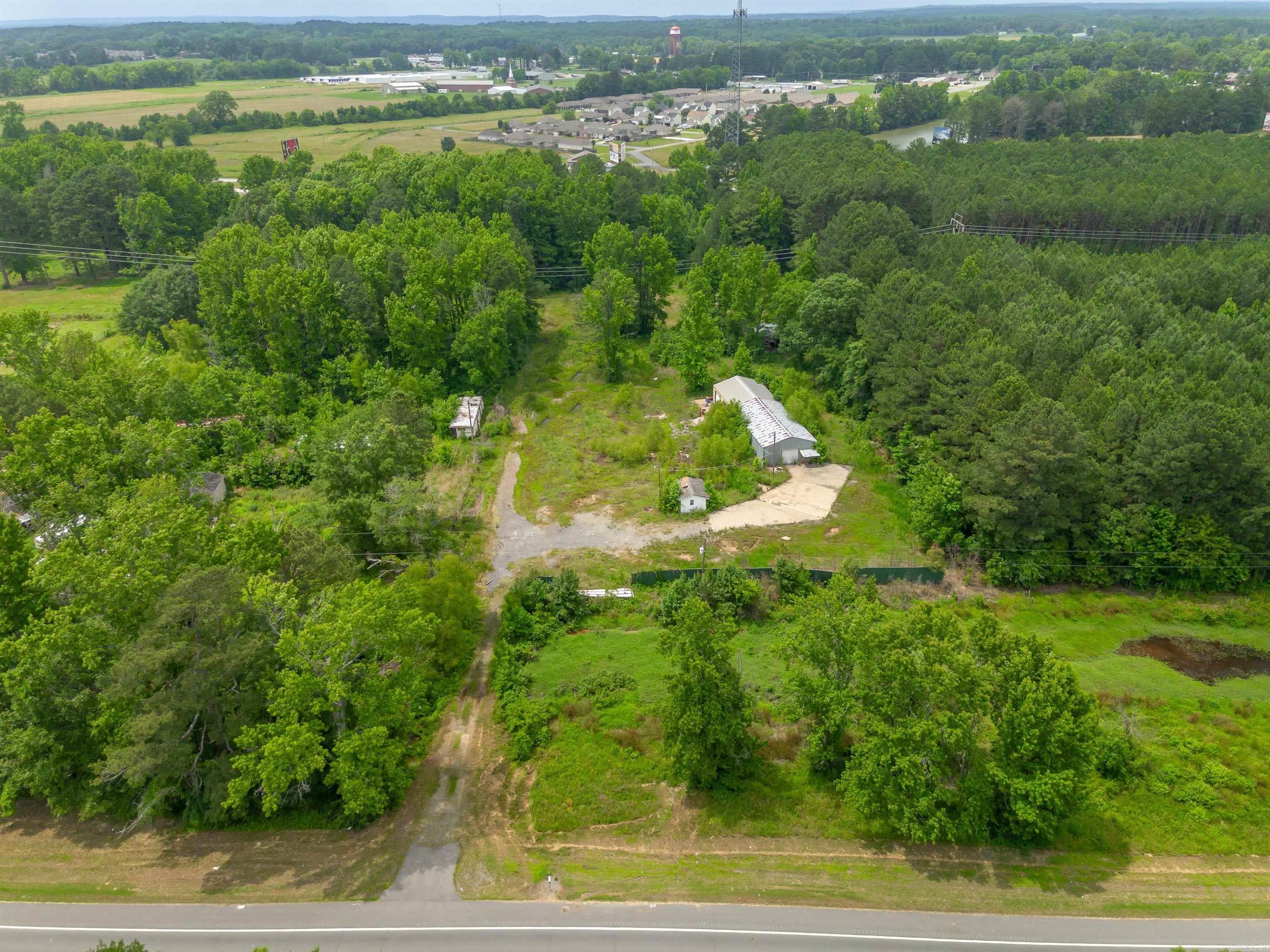 Located on a high-visibility stretch of Highway 367 S, this 5-acre property offers unique potential for both residential and commercial use. The front parcel is zoned C2 commercial, making it ideal for business opportunities, while the larger rear parcel is zoned R1 multi-use residential—offering flexibility for future development or expansion.  An easement has been granted, providing convenient access from the front commercial parcel to the rear residential section. This setup creates a seamless opportunity for a live/work setup, rental units, storage, or mixed-use investment.