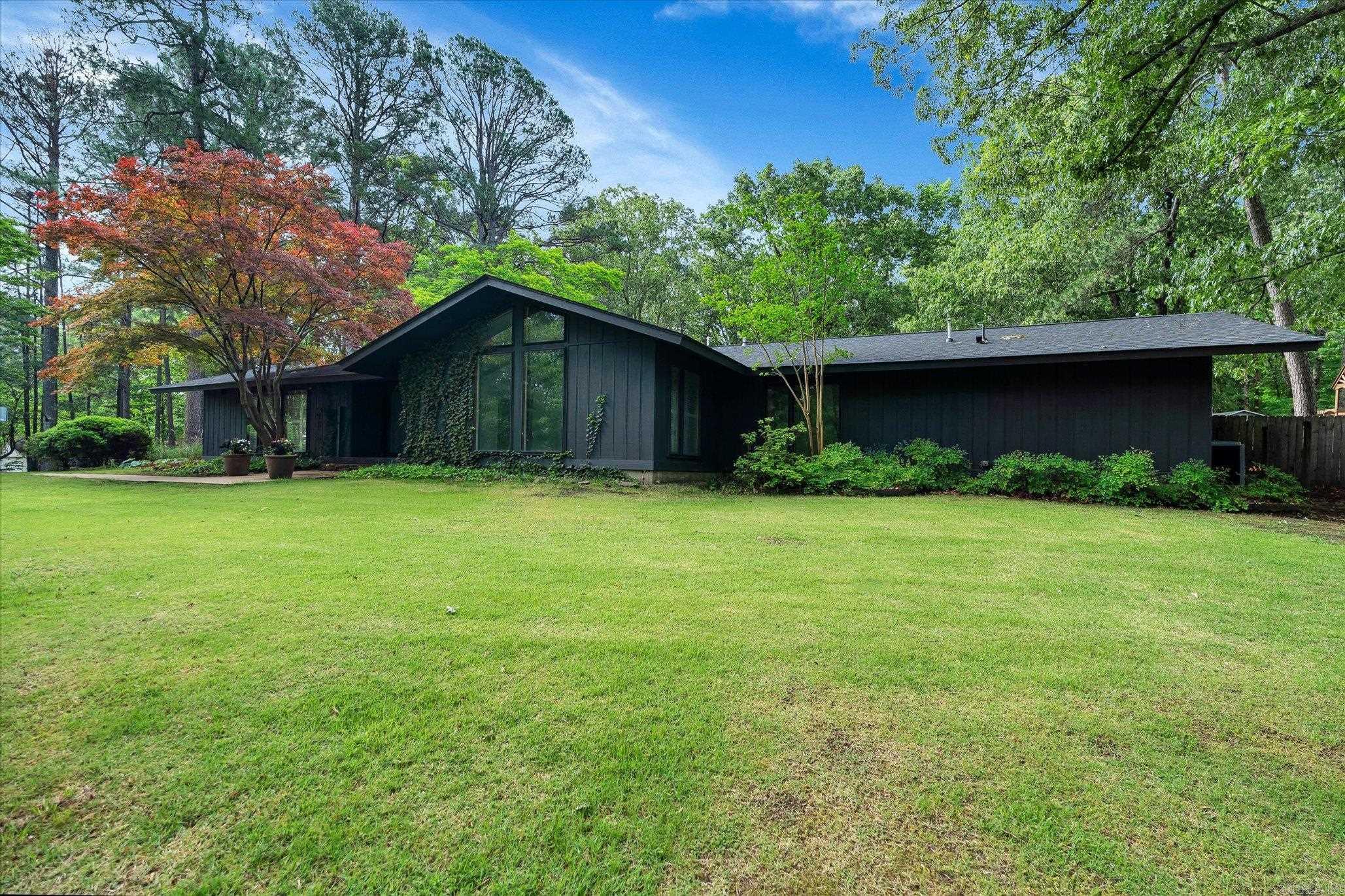 Mid-Century Modern inspired. Architect-designed. Personal. Local architect, Sid Frier, built 505 Jill Drive as his own residence a rare offering, tucked beneath a canopy of mature trees in the Valley View area. Three bedrooms. Two bathrooms. Approximately 2,880 square feet on nearly an acre. This is architecture with intention. Soaring ceilings. Exposed beams. Walls of glass that frame the trees outside like artwork because that was the point. Light moves through this home the way Frier designed it to, decades ago, and it still works. The kitchen has been brought forward without losing the thread quartz counters, custom cabinetry, a farmhouse sink, an oversized island, and a banquette built for everything from a quiet breakfast to a house full of people on a holiday. A stone fireplace anchors the main living space. The bathrooms pair timeless materials with finishes that feel current, not dated. At the center of it all a private courtyard and covered outdoor living space, an extension of the interior rather than an afterthought. Mature hardwoods and established landscaping surround the property, with a detached storage building for whatever a full life requires.