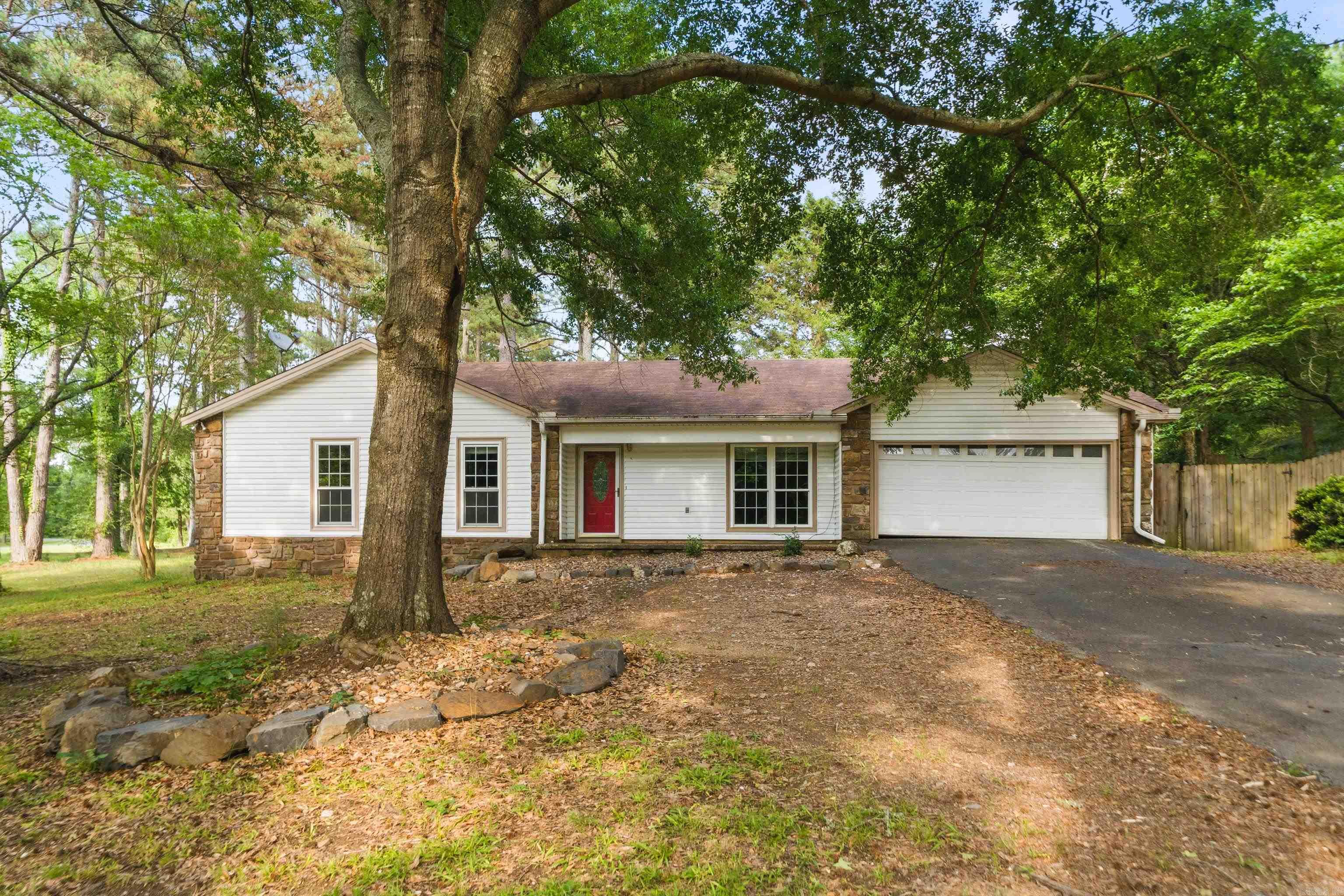 Beautifully updated and completely move-in ready! Nestled in a quiet country setting on a massive 1.47-acre lot, this traditional 4-bedroom, 2-bath home perfectly blends modern upgrades with cozy charm. Step inside to a spacious, open-concept living area anchored by a beautiful wood-burning fireplace, seamlessly connecting to a custom kitchen boasting sleek granite countertops, stainless steel appliances, and a convenient breakfast bar.  Remodeled in 2017 with gorgeous tile flooring, newer windows, and extra insulation for energy efficiency, this home is as practical as it is stunning. The flexible 4th bedroom makes a perfect home office or study. Outside, enjoy a spacious backyard complete with a privacy fence and a 2-car garage. Located in the Lake Hamilton School District and may qualify for Rural Development financing!
