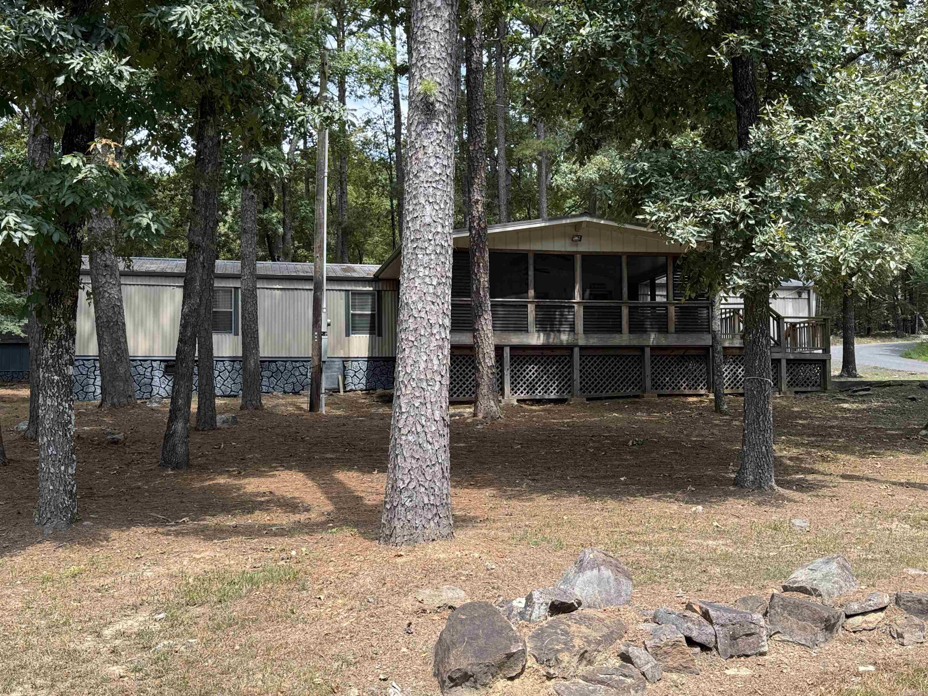 PERFECT LAKE VIEW CORNER LOT. This home is all electric with  3 bedroom 2 bath and comes with most furnishings. It sits on a .49 wooded lot with concrete driveway and a storage shed. Great area for permanent or a vacation home. Awesome covered screened front porch is super large for all your entertaining. Call Today !!