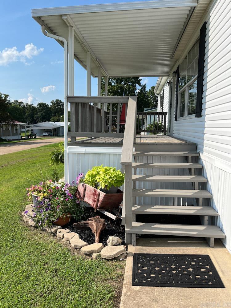 This 2003 double wide mobile home is anchored on a full cement pad and absolutely Move In Ready! New Roof 2026, New front siding 2026. It’s well insulated and has Thermopane windows. 3 Beds, 2 Baths, Bonus Room/Office with double door entry. The beautiful front door (new storm door) leads into the Large Living Room with big front windows.  Kitchen has tons of storage and approx. 4-year-old appliances. Gas Fireplace inspected and cleaned (11/25). HVAC less than 10 years old. New smoke and carbon monoxide detectors.  Sit on your large covered decks – One faces the woods behind the house to see the abundant wildlife, and the other overlooks the lake across the street. 2+ car carport. Nearly New Oversized Two Car Garage has been spray foam insulated and drywalled, has electric and LED lighting. Extra room in garage can be a separate workshop. There is a NEW tornado shelter in the garage as well! This is such a well-maintained property.  All you need to do is bring your belongings.