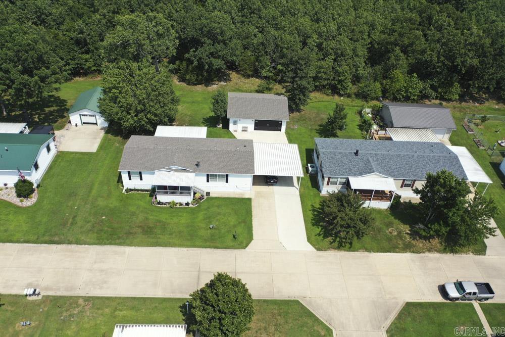 This 2003 large Dutch Mfg. home is anchored on a full cement pad and absolutely Move In Ready! New Roof 2026, New front siding 2026. It’s well insulated and has Thermopane windows. 3 Beds, 2 Baths, Bonus Room/Office with double door entry. The beautiful front door (new storm door) leads into the Large Living Room with big front windows.  Kitchen has tons of storage and approx. 4-year-old appliances. Gas Fireplace inspected and cleaned (11/25). HVAC less than 10 years old. New smoke and carbon monoxide detectors.  Sit on your large covered decks – One faces the woods behind the house to see the abundant wildlife, and the other overlooks the lake across the street. 2+ car carport. Nearly New Oversized Two Car Garage has been spray foam insulated and drywalled, has electric and LED lighting. Extra room in garage can be a separate workshop. There is a NEW tornado shelter in the garage as well! This is such a well-maintained property.  All you need to do is bring your belongings.