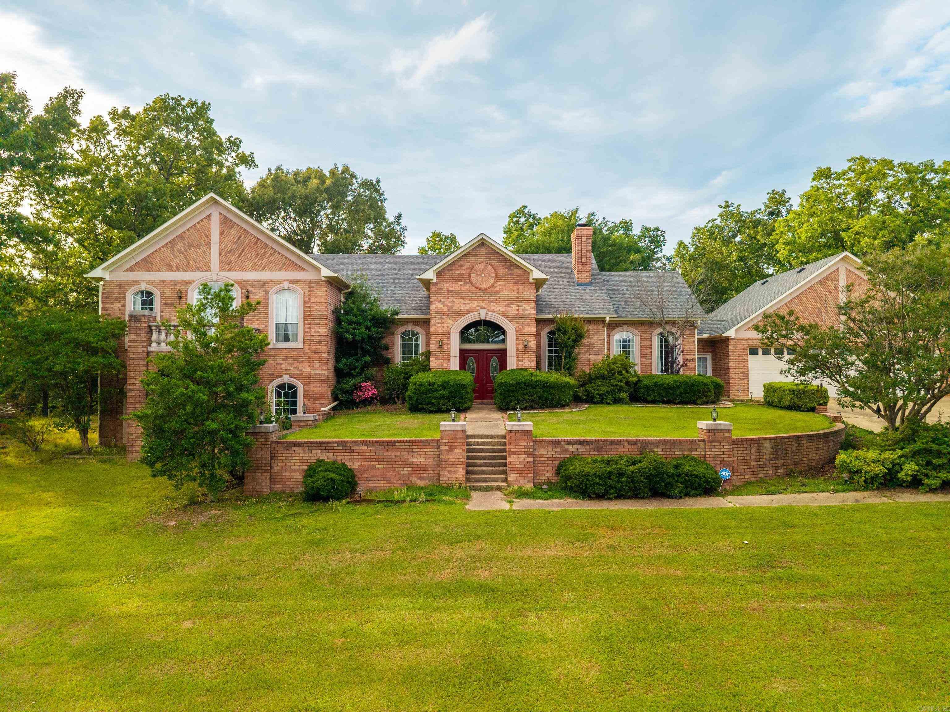 Beautiful home, 4.81 wooded acres with view of Lake Hamilton. This spacious home features about 3,400+sq ft,3 bed 2 1/2 bath. Tall ceilings, hardwood floors & warm finishes, multiple gathering spaces,  a layout that provides both openness & functionality. A cozy wood burning fireplace adds charm, while large windows bring in natural light & showcase peaceful surroundings. The home is equipped with a mix of modern conveniences including a well-appointed kitchen, ample storage, laundry area, dining area, & room for a home office, guest area, or hobby room. Split level with large master suite with shower/sauna, & large walk in closet. A nice deck to view deer and other wildlife in your front yard. 3 car garage. Outdoors, the property offers expansive acreage with a wet weather creek, wooded privacy, and room to enjoy nature, gardening, or future enhancements. Also, an in-ground pool for relaxing after a long days work & entertaining guests. Covered patio area. A large rv cover provides protection for your rv, boat, or tractor. Just minutes from shopping, dining, & all that Hot Springs has to offer. Lake Hamilton Schools. Vacant rooms are virtually staged for example only.