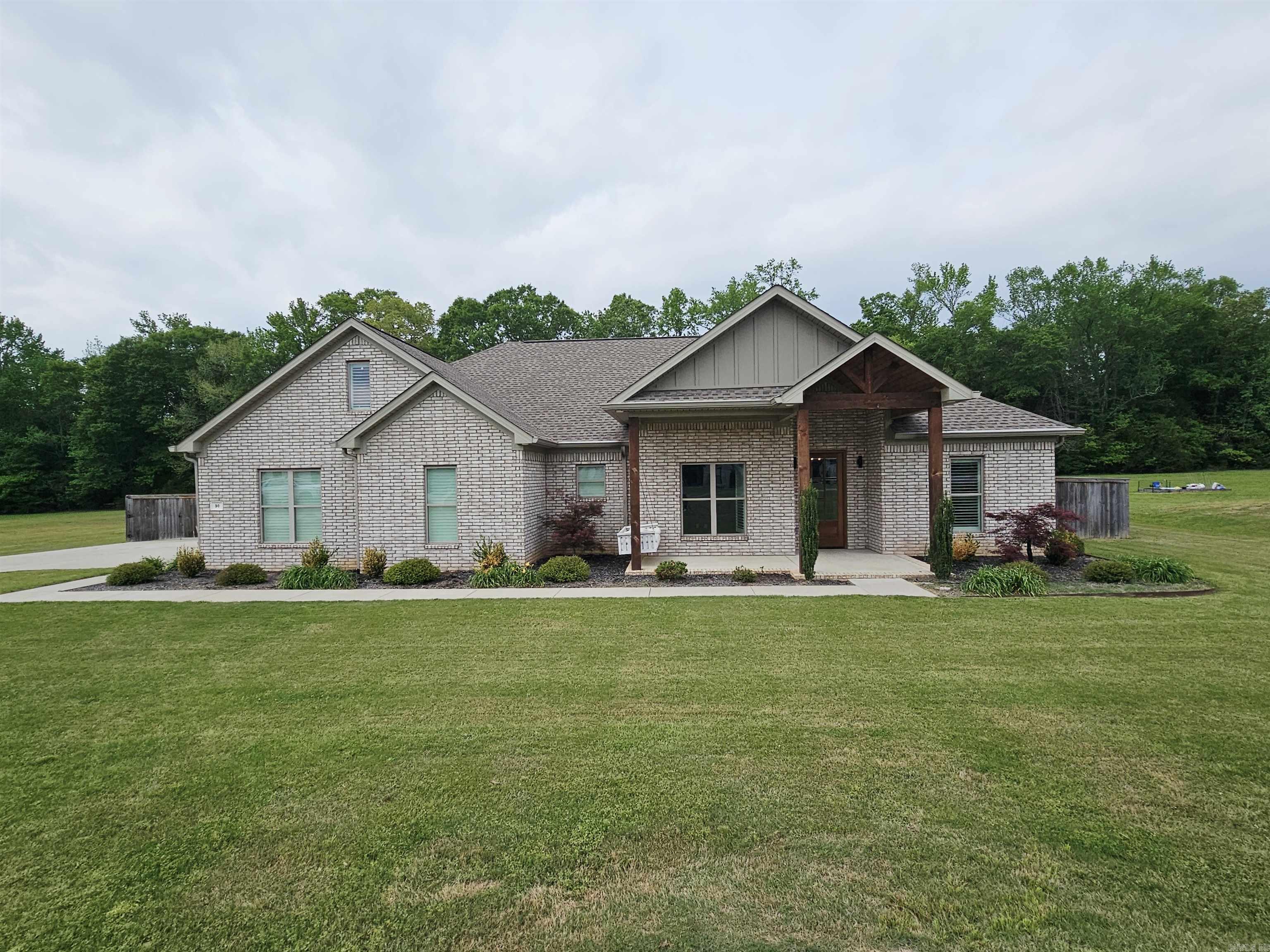 Like new and move-in ready, this stunning 4-bedroom, 2-bath home sits on a spacious 1-acre lot with a 2 car side entry garage.  Step inside to an inviting open floor plan featuring beautiful wood floors, fresh paint throughout, plantation shutters and a cozy gas log fireplace—ideal for both everyday living and entertaining.  The kitchen is a true standout with beautiful countertops, stainless steel appliances, a butler’s pantry, and ample cabinetry, while the laundry room also provides an abundance of storage.   The spacious primary suite features a large walk-in closet, double vanities and a beautifully appointed walk-in shower and tub.   Outdoors, you’ll love the inviting front porch swing, screened-in back patio complete with a doggie door and perfect for enjoying the peaceful surroundings. The backyard is designed for both relaxation and functionality with a hot tub, raised flower beds, RV/boat parking pad, and full fencing—all backing up to serene wooded nature views.  This one truly has it all!  Square footage is approximate, measuring is encouraged.