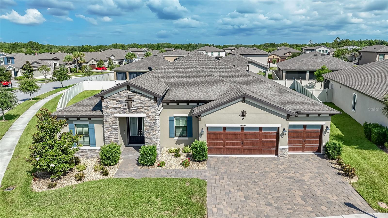 Rarely do homes combine MODEL-LIKE FINISHES, a sought-after floorplan, and a NEARLY ONE-THIRD-ACRE FULLY FENCED HOMESITE in one exceptional package. Lots of this size are almost unheard of in master-planned communities, offering endless POSSIBILITIES FOR A FUTURE POOL, Outdoor Entertaining, play space for young ones and pets, or simply room to enjoy your own PRIVATE BACKYARD RETREAT. METICULOUSLY MAINTAINED and showcasing true pride of ownership, this stunning WESTBAY BEACH PARK FLOORPLAN Provides 3,246 square feet of thoughtfully designed living space with 4 BEDROOMS, 3 FULL BATHS, a PRIVATE OFFICE with glass doors, FORMAL DINING ROOM, EXPANSIVE GREAT ROOM, BONUS ROOM, and a 3-CAR GARAGE with epoxy flooring. The desirable three-way bedroom split provides privacy for everyone, while the bonus room, fourth bedroom, and adjacent bath create an IDEAL SETUP FOR GUESTS, MULTI-GENERATIONAL LIVING, or an IN-LAW SUITE. Exceptional curb appeal welcomes you home with LUSH LANDSCAPING, STONE ACCENTS, elegant DOUBLE GLASS DOORS, and an oversized BRICK PAVER DRIVEWAY. Inside, SOARING CEILINGS, 8-FOOT DOORS, 5¼-INCH BASEBOARDS, PLANTATION SHUTTERS, CUSTOM LIGHTING, and WOOD-LOOK TILE FLOORING create an inviting atmosphere. The GOURMET KITCHEN is the heart of the home, featuring QUARTZ countertops, a LARGE ISLAND with BREAKFAST BAR, GAS COOKTOP, WALL OVEN, built-in microwave, FROSTED GLASS PANTRY DOOR, and abundant cabinetry, including GLASS FRONT CABINETS that add elegance while showcasing your favorite pieces. ADDITIONAL CABINETRY and COUNTER SPACE NEAR the DINING AREA make entertaining effortless. The stunning GREAT ROOM is highlighted by impressive DECORATIVE WOOD BEAMS that add Warmth, Character, and ARCHITECTURAL CHARM while emphasizing the home's SOARING CEILINGS. SURROUND SOUND in the GREAT ROOM and LANAI, along with EXPANSIVE SLIDING GLASS DOORS, creates the perfect setting for indoor-outdoor entertaining. The luxurious PRIMARY SUITE features a TRAY CEILING with CROWN MOLDING, PRIVATE LANAI ACCESS, TWO WALK -IN CLOSETS, and a SPA-LIKE BATH with QUARTZ Countertops, DUAL SINKS, SOAKING TUB, OVERSIZED WALK IN SHOWER WITH FLOOR-TO-CEILING TILE, and space for a makeup vanity. Located in the highly desirable CONNERTON COMMUNITY, residents enjoy a PEACEFUL, nature-filled setting with CONSERVATION AREAS, PONDS, and WALKING TRAILS, along with RESORT-STYLE AMENITIES including a Clubhouse, Community Pool, Fitness Center, Tennis Courts, Pickleball Courts, Basketball Courts, Playgrounds, and Dog Park. This exceptional home offers the perfect blend of luxury, functionality, and one of the largest homesites you'll find in the community. Don't miss your opportunity to make it yours!