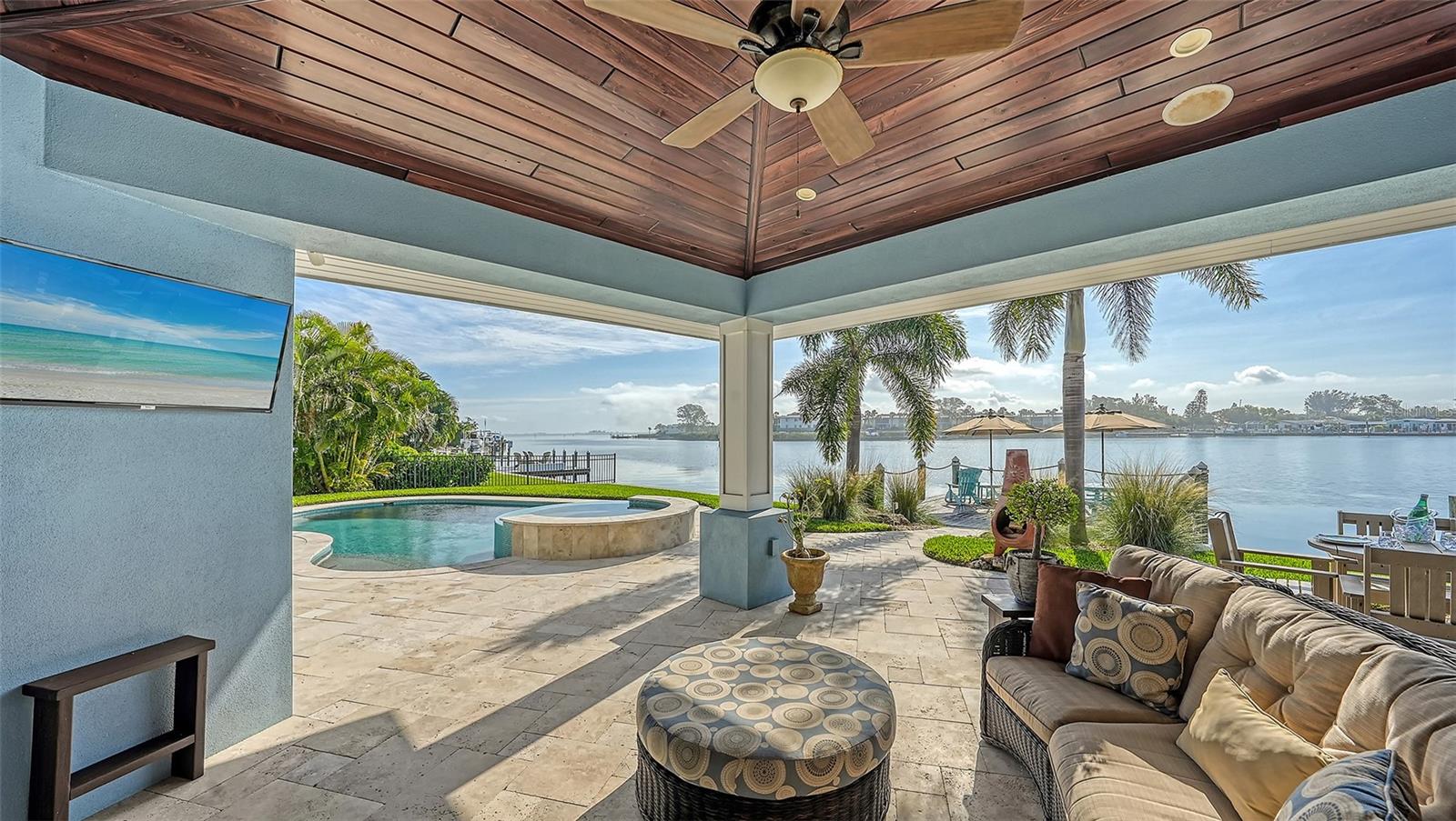 Under contract-accepting backup offers. Do you want to live in a beautiful waterfront home with outdoor kitchen, pool, dock and wide water views? Featured in Home & Design Magazine, this luxury waterfront home is in the Key Royale neighborhood of Holmes Beach. It is the epitome of gracious coastal living. Professional designers, attention to detail and high end finishes made this a one-of-a-kind home with its renovation down to the studs in 2016 including new electric, plumbing & seawall. Entering the Jeld-Wen double front doors, your first word will be "Wow!". Unfolding before you is a breathtaking great room with wide water (not canal) views, an expansive 1600+/- SF travertine pool deck, shaded loggia with custom wood ceiling, outdoor kitchen with hot/cold sink and Lynx propane grill plus 20' X 20' dock (with water & electric) on sailboat water (lift allowed). The great room is light-filled and includes custom built-in’s, fireplace, vaulted 15’ ceilings and full wall of hurricane impact sliders/windows showcasing long water views to Anna Maria Sound. The thoughtful design includes porcelain floors throughout (no carpet!) and an inviting kitchen worthy of a chef's dream featuring quartz counters, Mother of Pearl mosaic backsplash, custom cabinetry with roll outs (Campbell Cabinetry Designs), "Delta Touch” faucet, stainless farm sink, under cabinet lighting, 36" Wolf professional gas range with griddle, architectural range hood, Bosch dishwasher, Sub-Zero refrigerator with custom cabinet panels, Wolf microwave drawer and Wolf steam oven. The open floor plan is complemented by additional inviting spaces to enjoy your Florida lifestyle including a den with dual desk areas, sliders out to the loggia and barn door that ensconces the room into a functional home office, second lounging space or serene 4th bedroom. The waterfront primary bedroom is a luxury destination unto itself with water views, custom coffered 10' ceilings, plush ensuite bathroom, and direct access to the pool, spa, outdoor shower and water's edge. Getting ready for your day, you have the choice of two large closets with custom built-ins and your spa-like bathroom invites you to relax with its fine finishes including generously sized custom shower, quartz counters and refined tile work. For complete privacy, there are two additional bedrooms with sumptuous bathroom nestled on the other side of the home. All bedrooms were designed to be inviting, restful places with direct access to the lanai, pool and bay. The attention to detail continues in the luxe laundry room with raised LG appliances, quartz counters and floor to ceiling pantry with roll outs. For worry free living, this concrete block home was built to rigorous standards including a hurricane strapped metal roof, Hardie Board siding, Andersen Hurricane windows/sliders, 2 garages (one plumbed for conversion to a 4th or 5th bedroom/bathroom) and a TRANSFERRABLE FLOOD INSURANCE POLICY WITH A CURRENT PREMIUM OF $3800/YEAR. There's also a Trane HVAC system with Wi-Fi enabled thermostat, whole house surge protector, spray foam insulation, tankless water heater, WI-FI enabled garage doors, hard wired smoke/fire alarms, wiring for onsite and remote audio/video surveillance and bedside panic button. Imagine living the luxury lifestyle you've always dreamed of. Drift off to sleep as the moon rises over the bay, awaken to the glow of the sunrise on the water, then meander to the beach or enjoy the island's par 32 nine-hole private golf course. This could be yours!