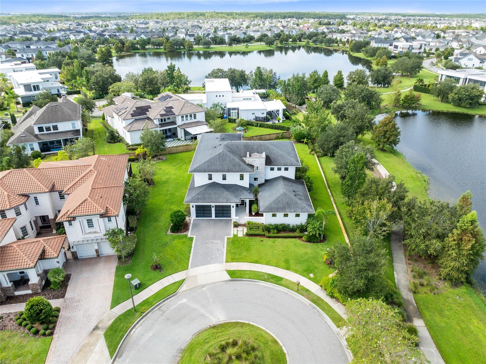One or more photo(s) has been virtually staged. This one-of-a-kind custom residence by the renowned Phil Kean Design Group redefines modern lakefront living in Laureate Park. A true architectural masterpiece, it offers 4,519 sq. ft. of heated living space and 6,074 sq. ft. total under roof, blending sleek design with everyday comfort. With five bedrooms, four full bathrooms, and one half bathroom, this is the only home of its kind in the community.

The heart of the home is the expansive great room with soaring ceilings, $20K designer chandeliers, and walls of glass that flood the space with natural light. The chef’s kitchen showcases waterfall-edge quartz countertops, custom cabinetry, premium appliances, and a large island with seating. Seamless indoor-outdoor living extends through sliding glass doors to the covered lanai and backyard with peaceful lake views.

The first floor offers versatility with a full guest suite and a spacious primary suite featuring a spa-like bath and walk-in closet. Upstairs, a second primary suite provides private balcony access, a luxurious bath, and a custom closet. Additional bedrooms and baths ensure comfort for family or guests, while the oversized bonus room serves as the perfect entertainment lounge with space for both seating and games.

Step outside to enjoy multiple outdoor living areas, including the expansive lanai designed for dining and lounging, and an upper balcony with sweeping water views. The lush, oversized backyard is one of the largest in Laureate Park—ideal for creating your dream pool, outdoor kitchen, or garden oasis, while still leaving plenty of open green space for play and entertaining.

Laureate Park isn’t just a neighborhood—it’s a vibrant lifestyle. Enjoy the Aquatic Center, resort-style pools, LP Fit gym, and 44+ miles of trails. Located in prime Lake Nona, minutes from Medical City, the VA hospital, Nemours, dining, and shopping. Close to major highways, Orlando International Airport, and the USTA National Campus. Easy access to Orlando’s top theme parks and beautiful Florida beaches.

This Phil Kean Design Group original blends architectural distinction, space, and community in a sought-after location. Schedule your private showing today and experience the best of Lake Nona living.
