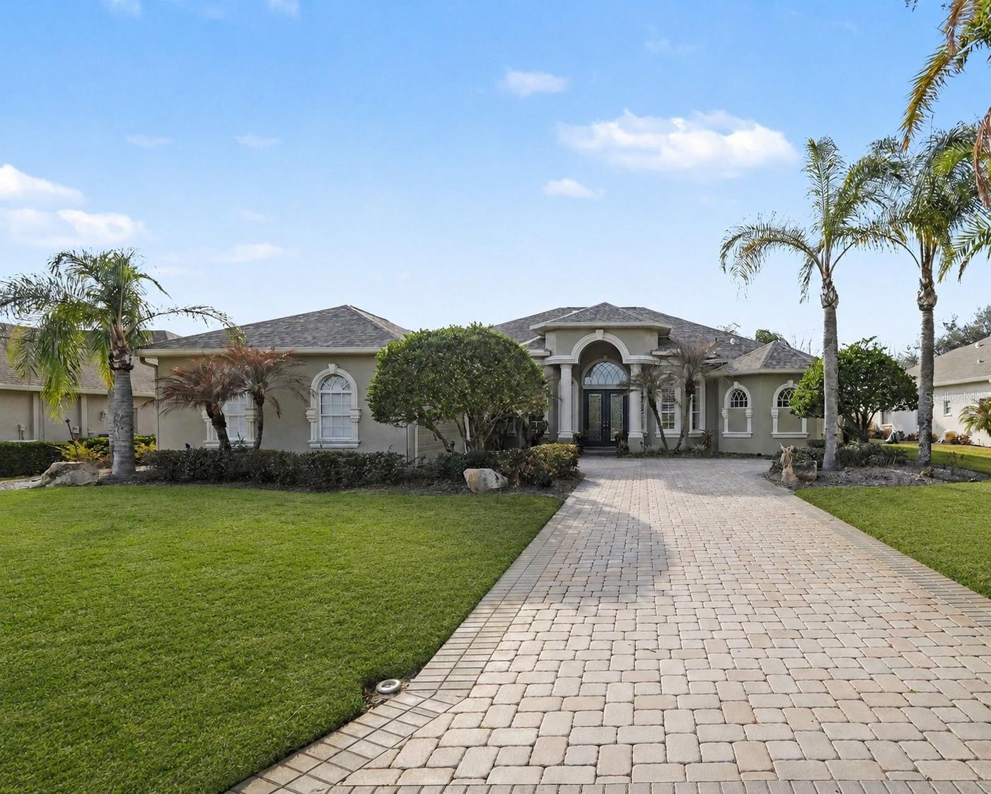 Spectacular Sunsets at Lake Jovita Golf & Country Club, where Casual elegance meets breathtaking golf course views of the North Course. This MUST SEE executive pool home welcomes you through  leaded glass double doors into a dramatic grand foyer, immediately drawing your eye through the expansive living area to stunning outdoor vistas. A spacious office with French doors sits just off the entry, ideal for working from home. Beyond the living space, the resort-style pool with soothing waterfalls creates a showstopping backdrop, seamlessly integrated with the game room—an exceptional space designed for entertaining and making lifelong memories with family and friends. Tray ceilings, Columns, arches, plantation shutters with custom sunburst louvers, wide crown molding, and exquisite attention to detail elevate the home’s refined design throughout.  Offering approximately 3,240 square feet, this impeccably maintained residence features Great room with tray ceiling & surround sound, dining room with columns and plantation shutters, three bedrooms, three full baths, plus a den/office, off foyer, Bonus/flex room at rear off pool and a side-entry three-car garage with third bay access from the side of the home. Gourmet kitchen boasts Custom 42" wood cabinets with crown molding, medallion corners & washed finish, wine rack, plate rack, under mount lighting, pot drawers,  Stainless appliances, Bosch dishwasher, Granite center island, archway to formal dining room and eat in breakfast nook with rounded wall overlooking POOL and golf course! Interior Laundry room with window, utility sink and extra storage is a plus! Split bedroom plan has the secondary guest bedrooms and full bath on one wing, the Primary Owners suite on the opposite end with luxurious bath ensuite and curved wall with lanai access and pool views. Bonus room and full bathroom are on a 3rd wing and can be used as an in-law suite, 4th Bedroom or game room with private entrance. Outside, the screened lanai is truly spectacular, providing a generous and inviting entertaining area complete with a gorgeous heated pool, outdoor bar, and built-in grill. Brick paver medallion accent in the driveway, paver walkways with lush, well-manicured landscaping delivers striking curb appeal!  Notable upgrades include a 2023 architectural shingle ROOF, 2 Lennox 2023 AC units for energy efficiency, new pool heater and pump, Bosch appliances, water softener, and stamped concrete lanai. Great Location in Lake Jovita Golf & Country Club, in the Hills of East Pasco, a Gated Community with private streets and optional memberships (fitness, social, golf & tennis), no CDD fees and low quarterly HOA which includes common area maintenance, walking trail with exercise stations, dog parks, tennis, pickleball, basketball, playground, picnic pavilion with grills and open fields. North of Tampa between the popular Wesley Chapel and Historic Dade City...this Lexington built, exceptional home is a true sanctuary and a rare opportunity to enjoy Florida living at its finest!  CALL TODAY!