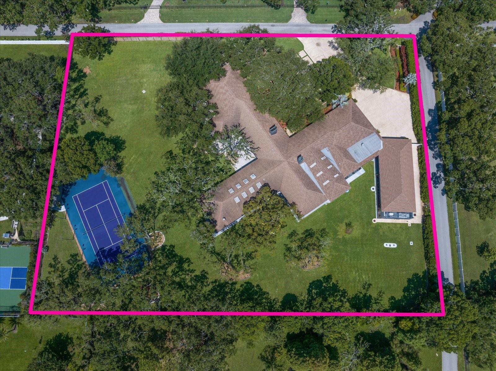 Hidden within the private enclave of Kent Place, this extraordinary Clearwater estate feels less like a residence and more like a world of its own. Set beneath majestic oaks on beautifully manicured grounds, the property blends grand-scale entertaining, resort-inspired amenities, and unmatched flexibility into one unforgettable offering.

From the moment you step through the gallery-style foyer, the home unfolds as a series of immersive spaces designed to surprise and inspire. A striking Key West-inspired retreat, complete with hand-painted murals, skylights, and dramatic walls of glass, creates an atmosphere that feels transported straight from the southernmost point of Florida.

Designed for both intimate evenings and large-scale entertaining, the living spaces flow effortlessly from a sophisticated formal dining room to a richly appointed family room with fireplace, wet bar, cigar cabinet, and WINE CELLAR. At the center of the home, the chef’s kitchen is outfitted with premium stainless steel appliances, an oversized island, and seamless access to one of the estate’s most remarkable features—an enclosed INDOOR POOL AND SPA surrounded by custom murals celebrating Tampa Bay’s most iconic landmarks. Glass accordion doors allow the space to transform from private retreat to entertainer’s showpiece in moments.

The primary suite is a private sanctuary unto itself, featuring a dedicated office, secondary laundry, custom built-ins, spa-inspired bath, and an extraordinary multi-level cedar-lined dressing room with illuminated glass cabinetry and exceptional storage throughout.

Guests are treated to a dramatic, castle-inspired suite complete with soaring ceilings, STEAM ROOM, SAUNA, whirlpool tub, and walk-in shower, while two additional ensuite-style bedrooms offer abundant natural light and walk-in closets.

Ideal for multigenerational living, long-term guests, or private staff accommodations, a separate two-bedroom, two-bath residence includes its own kitchen, living areas, and theater room.

For the automotive enthusiast, the estate offers an exceptionally rare collector’s garage experience with six bays, four lifts, and capacity for up to 10 vehicles, in addition to a separate three-car garage and expansive utility and storage spaces.

IMPACT-RATED WINDOWS AND SHUTTERS, MULTIPLE GENERATORS, custom craftsmanship, and thoughtfully curated details at every turn elevate the property into a category rarely found in Tampa Bay. Just minutes from world-class beaches, shopping, dining, and two international airports, 1835 Alicia Way is a statement estate designed for those who value privacy, creativity, and a home unlike anything else on the market.
