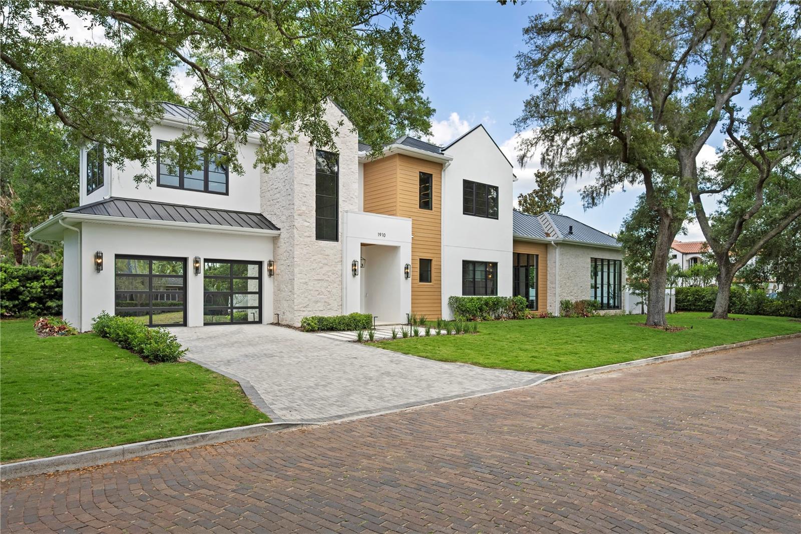 Under contract-accepting backup offers. 2026 PARADE OF HOMES ENTRY! - Positioned on an expansive corner lot in the heart of Winter Park, this extraordinary new masterpiece is a true architectural statement, delivering a level of craftsmanship and detail that is simply unforgettable. Framed by a massive front yard and a canopy of mature trees, the bold modern façade creates an immediate sense of arrival and sets the tone for what lies within. A grand set of double doors opens to a breathtaking two-story entry, where a dramatic marble mosaic feature establishes the home’s elevated design from the moment you step inside. The main living space is nothing short of stunning, anchored by a sleek electric fireplace and custom built-ins with integrated LED underlighting. At the heart of the home, the chef’s kitchen is a true showpiece, outfitted with Dekton Cosentino countertops, a paneled refrigerator, a full suite of Thermador appliances, and a hidden walk-in pantry. The kitchen flows effortlessly into the dining room which is bathed in natural light from an oversized statement window, making it perfect for hosting at any scale. Designed with versatility and luxury in mind, the home features two primary suites, one on each level. The downstairs primary offers soaring 12-foot ceilings and a serene, spa-like bath wrapped in marble mosaic tile. Upstairs, the main primary suite is a true showstopper, defined by its scale and attention to detail. Dual custom closet systems include an expansive hers closet complete with a dedicated makeup vanity, while the bathroom delivers a resort-caliber experience with stunning marble floors, a freestanding soaking tub, and dual vanities. The upper level continues to impress with a spacious loft designed for both relaxation and entertaining, complete with a custom entertainment center, wet bar, wine fridge, and a full bath. Each additional bedroom is ensuite, offering privacy and comfort for family and guests alike. Outdoor living rivals that of a private resort. A massive covered lanai features a fully equipped summer kitchen with tile backsplash, overlooking an expansive lounging area framed by a wall of glass. The heated pool and spa create the ultimate setting for year-round enjoyment, while the oversized front yard (an incredibly rare find in Winter Park), adds an unmatched sense of space and setting rarely found in this market. Additional features further elevate the home, including a sleek metal roof, striking hex LED lighting in the garage, and curated designer lighting fixtures throughout. Perfectly positioned just moments from Lake Chelton and Virginia Heights Park, with easy access to the boutiques and dining of Park Avenue and the charm of Hannibal Square, this residence offers a lifestyle that is as elevated as the home itself.