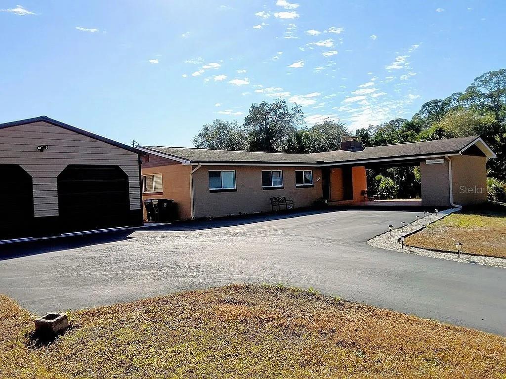 At the very end of a secluded roadway sits a 3 Bedroom 3 bath home  on a private 1.61-acre retreat, offering space, security, and flexibility rarely found this close to town. Surrounded by open land and mature surroundings, this solidly built concrete block residence delivers a layout designed for comfort and function. Natural light fills the main living area through expansive windows that frame wide, uninterrupted views of the property. The kitchen serves as the heart of the home with marble surfaces, updated appliances, and generous workspace. Wood flooring extends throughout, and each bathroom features modern walk-in showers for a clean, streamlined feel. Outdoors, the setting transforms into your own recreational compound. A 40' x 15' pool with dedicated heat pump allows for extended seasonal use, while the covered porch provides the perfect vantage point to enjoy the peaceful surroundings. The detached oversized garage/workshop, additional covered parking, new asphalt drive, and secure sliding gate create both convenience and privacy. Infrastructure updates include a 2018 roof, new 4" gutter system, front and back door Ring cameras primary and backup wells, and dual septic systems — offering long-term practicality and independence. The acreage provides room for expansion, additional structures, RV/boat storage, or other future possibilities (buyer to verify). Located just moments from Parrish Medical Center, Marina Park, and US-1 access, this property combines privacy, land, and accessibility in one distinctive offering.