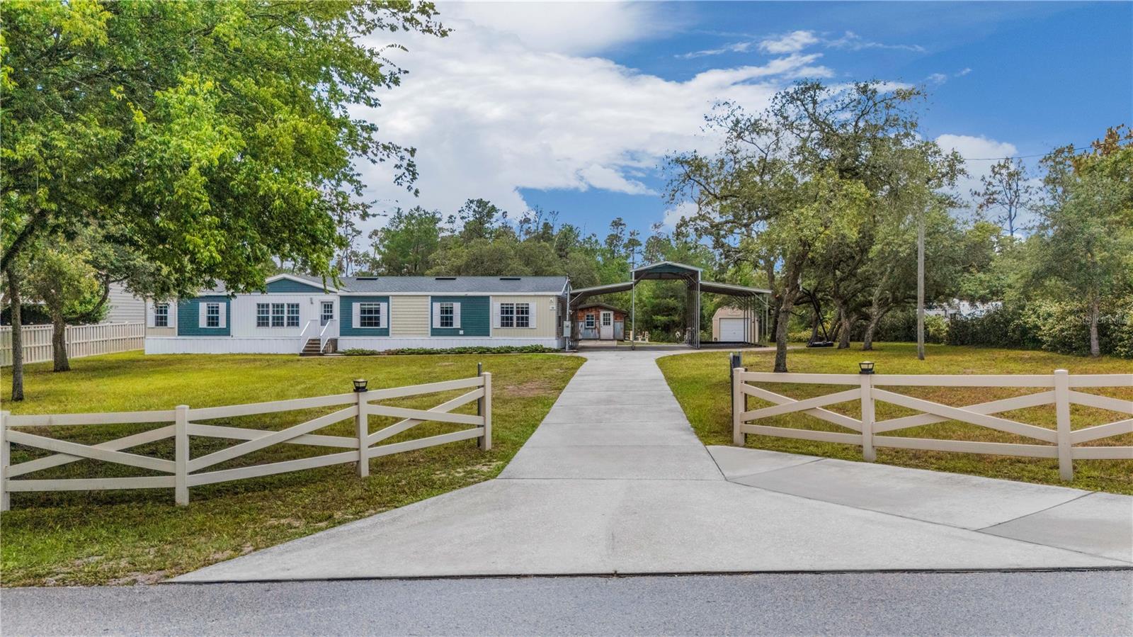 BEST OF ALL WORLDS — SPACIOUS, METICULOUSLY-MAINTAINED 4 BEDROOM/2 BATHROOM MANUFACTURED HOME boasting 2,280 SQFT nestled along a quiet PAVED ROAD on a NEARLY 1 ACRE LOT (0.8 acres) conveniently located less than 5 minutes from major roadways (SR 50 & Suncoast Parkway/SR 589), shopping, dining, schools, parks, healthcare facilities (including a VA Clinic), entertainment, & so much more. This home offers the RARE OPPORTUNITY to own a SIZABLE LOT IN THE HEART OF HERNANDO & FREEDOM TO ENJOY IT — NO HOA/CDD/DEED RESTRICTIONS & ZONED AR-2 — IT’S TRULY THE BEST OF BOTH WORLDS! The EXPANSIVE FRONT YARD lined with a CHARMING CROSS-FENCE generously separates the home from the road, offering MAXIMAL PRIVACY. You’ll feel right at home as you pull into the GATED DRIVEWAY and make your way to the THREE-STALL LOFTED CAR/RV PORT complete with 50 AMP & WATER HOOK UPS. Step inside to discover the UTMOST INVITING & FUNCTIONAL FLOOR PLAN that seamlessly connects the living room, dining room, and massive kitchen —perfect for both entertaining and day-to-day living. The SPLIT-BEDROOM LAYOUT offers privacy, with a GENEROUSLY-SIZED PRIMARY SUITE featuring ample closet space and a well-appointed en-suite bath. On the other side of the main living/dining area is a hallway leading to the additional three bedrooms (one is currently used as an office), second full bath, laundry/utility room with exterior door to the backyard/carport, & a SHOW-STOPPING FAMILY/GREAT ROOM that runs the entire width of the home and features EXQUISITE WAINSCOT PANELING throughout, wet bar, & additional dining/craft area. The SIZABLE KITCHEN boasts a VAULTED CEILING, TIMELESS WHITE WOOD CABINETRY, STAINLESS STEEL APPLIANCES, CLOSET PANTRY, and tons of counter and storage space. The kitchen flows into the SPACIOUS DINING ROOM, that is highlighted by TASTEFUL BUILT-IN BUFFET & SHELVING and FRENCH DOORS that open to a COVERED SCREEN PORCH overlooking the fully-grounded ABOVE-GROUND POOL that is flawlessly integrated into an IMPECCABLY-DESIGNED DECK & DRAINAGE SYSTEM. A portion of the yard, including the pool & deck area is enclosed by a chain link fence and can serve as a dog run/animal enclosure. The other side of the yard features a custom fire pit, a cabana/workshop with deck, & 12’x24’ shed. The upgrades on this property go beyond the surface and offer immense peace of mind (& insurance discounts) including — a PATENTED ‘BYRD FOUNDATION’ ANCHORING SYSTEM utilizing longitudinal central and exterior slabs (not standard piers & tie-downs) which can withstand winds up to 175 mph, FRESHLY PAINTED DRYWALL WALLS/CEILINGS, double-pane vinyl windows, BRAND NEW HOT WATER HEATER (2025), NEWER ROOF (2019), poured concrete stairways to both front and back doors, NEW POOL PUMP (2025), just to name a few. This SUPERB HOME is not to be missed — you have to see it to believe it! Schedule your private showing today!