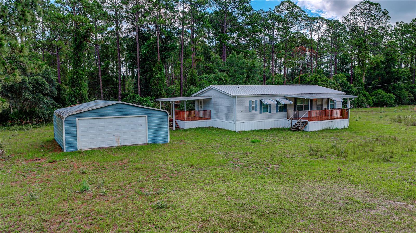 Fully Furnished Country Retreat on Nearly an Acre! Welcome to this well-maintained 3-bedroom, 2-bath doublewide with 3 car detached workshop,  situated on three combined parcels totaling approximately 0.92 acres. Tucked away among mature trees and just a short distance from the water, this property offers the perfect blend of privacy, space, and peaceful Old Florida charm. Step inside to find a spacious and inviting floor plan featuring a large living area, generously sized bedrooms, and a bright kitchen with abundant cabinetry and counter space. Best of all, all furnishings are included, making this a truly move-in-ready opportunity—ideal as a primary residence, seasonal getaway, or investment property. Outside, you'll appreciate the expansive yard with plenty of room for boats, RVs, recreational equipment, or future outdoor projects. The impressive 784 sq. ft. detached garage/workshop provides ample space for vehicles, storage, hobbies, or a home-based business. A covered front porch offers the perfect spot to relax and enjoy the peaceful surroundings. Whether you're looking for extra space, a fully furnished home, or a property with a large workshop, this unique offering checks all the boxes. Don't miss your chance to own nearly an acre of Florida living with room to spread out and enjoy! Highlights include: 3 bedrooms, 2 bathrooms; all furnishings included; 3 parcels totaling approximately 0.92 acres; large 784 sq. ft. detached garage/workshop; spacious floor plan with abundant storage; covered front porch; plenty of room for RVs, boats, and outdoor toys; and move-in ready! Georgetown is a secluded lakeside community near Palatka.  John's river flows into Lake George and all the nearby by nature areas, with forest lands all around, and popular destination for any outdoor enthusiast. Popular attractions nearby include Lake George Conservation area, DeLeon Springs State Park, Georgetown Cove Commons, Salt Springs Rec Area, Welaka State Forest, Silver Glen Springs, Devils Millhopper Geological State Park , Forest Riverfront, and more! Fully furnished just move in!