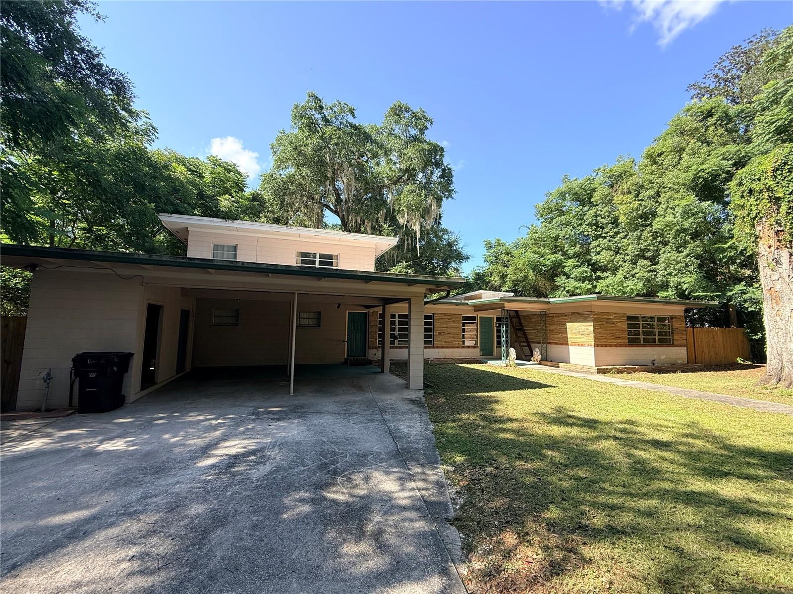 This is a prime investment opportunity for any buyer looking to create a home in the heart of Gainesville or for the buyer looking to create a rental unit or several under one roof. This well-appointed mid-century modern residence boasts almost 3,300 sq ft and is only 3/4 of a mile to the northeast corner of the University of Florida campus. There are five bedrooms, 3 bathrooms, a bonus room to serve as a den or office space, a formal living room, a formal dining room, a family room, a laundry room, and even a pantry room. Given the large square footage and split plan of the building, the home could easily be converted into multiple sections for a multi-generational or income-generating arrangement. There is a double carport, almost a third of an acre of property, a fully-fenced in backyard, a wood-burning fireplace, and built-in bookshelves.