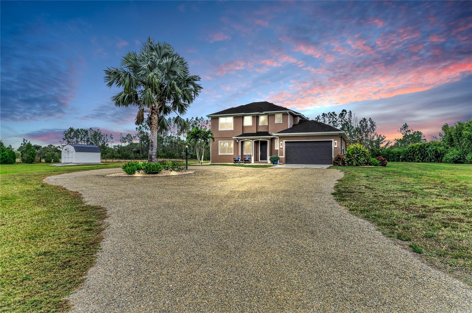 Golf lovers and outdoor enthusiasts will feel right at home at this private 4.5-acre estate, where a 30’ x 20’ putting green sits beside a stunning 20’ x 40’ saltwater sport pool with a 9-foot sun shelf and relaxing hot tub. Designed for effortless outdoor living, the expansive 52’ x 12’ covered patio features a tongue-and-groove ceiling, recessed lighting, and fans, while a 20’ x 8’ motorized Kevlar screen creates a comfortable, flexible space for entertaining year-round. A 16-panel solar system producing approximately 30–40 kWh per day helps power the home, paired with an 18 kWh Generac battery backup to enhance efficiency and provide added peace of mind during outages. Surrounded by lush tropical landscaping, the fully fenced property includes a gated entry and offers exceptional privacy with NO DEED restrictions or CDDs. Inside, this custom Mark Cahill home features three bedrooms and two and a half baths with an open floor plan designed to maximize natural light. The great room impresses with soaring volume ceilings that create an airy, inviting atmosphere ideal for both everyday living and entertaining. The chef’s kitchen is beautifully appointed with a stylish tile backsplash and stainless-steel appliances. The first-floor primary suite provides a peaceful retreat with dual sinks and a spacious walk-in shower. Upstairs, two additional bedrooms share a cozy loft area perfect for a home office, media space, or playroom. Modern comfort and efficiency continue with a new Carrier HVAC system with air purifier and UV lamps, along with Nest thermostats for optimal climate control. Security features include Ring spotlight cameras and a doorbell for added peace of mind. Despite its serene setting, the property is just minutes from restaurants, hospitals, UTC Mall, and shopping, and approximately 12 miles from I-75, offering the perfect balance of privacy and convenience. This unique estate blends luxury outdoor living, energy efficiency, and wide-open space into a lifestyle that feels like your own private retreat.