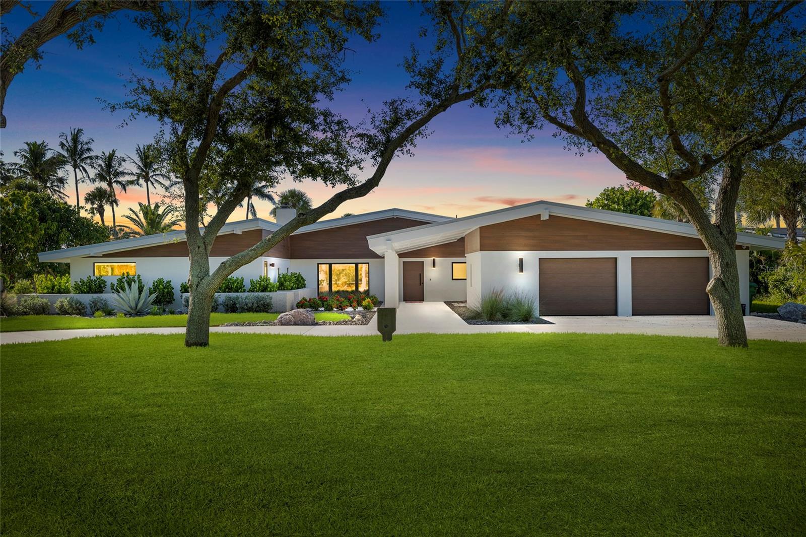 Stunning Mid-Century Modern deep, protected waterfront Showcase – Remodeled to Perfection! Located on the Intracoastal Waterway, inside pristine Pelican Bay and just around the corner from Boca Grande, Gasparilla Pass and the Gulf of America ... No expense was spared sculpting this 4 bedroom, 3 bathrooms + 2 additional 1/2 bathrooms, 2 car plus garage Masterpiece. As you drive in/walk in, lush tropical landscaping leads to an inviting Courtyard interior highlighted with a view through expansive Hurricane rated pocketing Sliders featuring panoramic blue water and sunset views. Designed for the ultimate coastal lifestyle, this home transitions effortlessly from refined indoor comfort to spectacular outdoor living. The home’s coastal-inspired architecture gives way to bright, open living spaces curated for both comfort and sophistication. The Chef’s Kitchen and secondary Prep Kitchen is an entertainer’s dream – boasting a large center island, stainless large propane range, designer range hood, pot filler, convection oven/microwave combo, wine fridge, dual dishwashers, dual refrigerators/freezers – open to the spacious great room, dining space and a fun and functional family room, where expansive sunset bay views set the tone for relaxation. The master suite has comfort in mind, featuring a large walk-in closet, a dual vanity, water closet featuring Toto toilet with bidet, and an oversized twin shower spa-like retreat. Off the garage and the Master wing there is a large laundry room with sink, lots of storage, and a separate enclosed tackle room/exercise room with its own ingress and egress. Three additional bedrooms and two luxurious guest baths, plus two additional powder rooms ensure a warm welcome for family and friends. Boaters will delight in this dream setup – complete with new seawall, new dock with two boat lifts (10,000 lbs and 13,000 lbs), a kayak/paddleboard launch and quick access to open water/back waters, azure Gulf waters, and white sandy beaches providing excellent shelling. The rear patio invites you into Resort-style outdoor living with newly installed Aquatech designed pool and an exceptionally large spa to match, along with a large covered patio to entertain your guests. Your daily front-row seat to protected, unforgettable Gulf sunsets. Remodeled as new with Impact rated windows and doors, a durable Metal Roof, tropical landscaping featuring beautiful night lighting, irrigation, fencing, new HVAC systems, tankless hot water heater, wireless security system and much more! PROPERTIES OF THIS MAGNITUDE ARE A RARE FIND! A seamless blend of luxurious living, fulfilled adventure, and serene coastal beauty. Please take the time to walk through this Masterpiece Remodeled to Perfection!