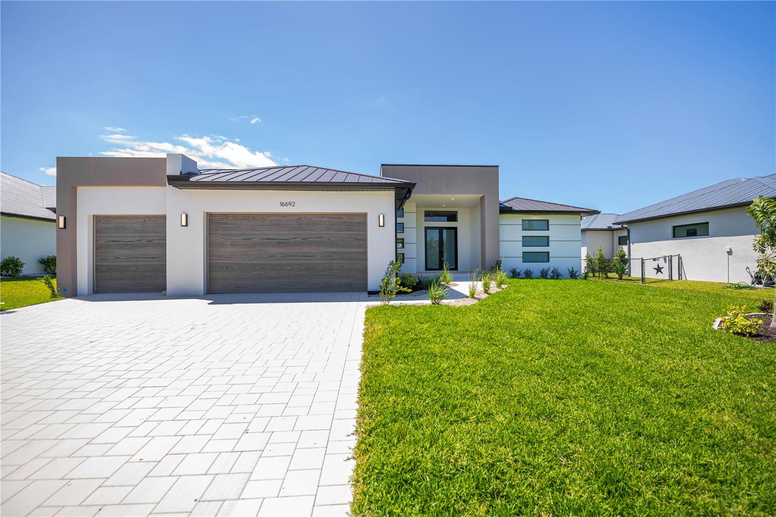 One or more photo(s) has been virtually staged. STUNNING GULF ACCESS custom built 4/3/3 pool home in the most sought after area within the waterfront community of South Gulf Cove. Overlooking Serene waterway across a preserve, this home offers exquisite luxury, breathtaking views, an idyllic Florida lifestyle come true.This sleek, modern masterpiece showcases clean lines and incredible curb appeal with a contemporary paver walkway and driveway, manicured landscaping, soaring entryway, MAJESTIC BRONZE METAL ROOF, custom doors, designer lighting and distinctive vertically stacked horizontal windows, pure elevated modern elegance. Step inside the foyer to an open floor plan flooded with dramatic lighting & tiered tray ceilings, porcelain plank tile, low profile linear air vents, all crafted with superior finishes throughout.Your living room features a contemporary marble accent wall, floating electric fireplace media wall w pocketing sliding doors seamlessly connecting indoor/outdoor/ pool/ water views. Your chef worthy kitchen boasts quartz counters and backsplash, deluxe appliances, chimney range hood, glass pendant lighting, double stacked elevated cabinetry, waterfall edge breakfast bar perfect for everyday or fine dining. Triple windows display magnificence within the contemporary dining room adjacent to your kitchen affording choice water views and effortless entertaining. The versatile den, enclosed w sleek frameless glass double doors, fills with ambient natural light & offers panoramic water vistas, ideal for an office or hobby room. The zen-inspired primary suite is a private retreat with patio, pool, and outdoor kitchen access, tray ceiling, sky enhancing clerestory window, California Closets, and spa like ensuite bath. The luxurious bath features split vanities, gold trim mirrors, upgraded design trend of a glass enclosed wet room highlighting a freestanding tub wet room area complimented with bench seating for exceptional centralized drainage. A resort steam room experience, perfect a true spa pampering. Three spacious guest bedrooms offer modern convenience and stunning aesthetics. Two exceptional bathrooms service the main home and extra bedrooms inclusive of a convenient pool bath. The show stopping screened and caged pool area includes vast views through picture frame screens, a paver deck, an integrated sitting spa positioned for an immersible view and crafted resort style with a fully equipped professional outdoor kitchen. Sailboat access w preserve views plus extra greenbelt in front add extra privacy, an extra deep yard, luxury and a truly unique opportunity. Enjoy unmatched craftsmanship, incredible cross breezes, and every modern outdoor living comfort beneath the covered tongue and groove wood ceiling, your ultimate Florida lifestyle awaits. Swim & live in luxurious privacy day or night while experiencing all the nature and gulf have to offer with every imaginable modern comfort at your fingertips. Additional standout features include unbeatable water views, no HOA, public water and sewer, outdoor shower, over 110k of custom upgrades w 3 car garage ready to accommodate all your toys.SGC community amenities include a Boat Ramp, nearby marinas, expansive parks, & playgrounds perfect for family fun, outdoor adventures & are OPTIONAL HOA. Enjoy close proximity to fantastic dining, shopping, world class fishing, top golf courses, and so much more. Here is the nature sanctuary you've waited for so don't delay, SCHEDULE your showing TODAY