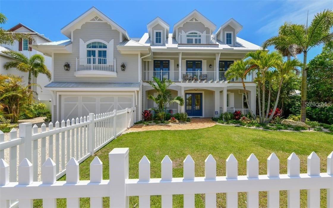 Welcome to your island oasis! This stunning modern waterfront home redefines relaxation. Step through the double front doors and behold the tropical backyard. Ascend to the main living level via custom handrail-adorned stairs or the convenient elevator. The open-concept space features 8” white oak wood floors, wood-beamed ceilings, and designer Reginald Andrews lighting. The gourmet kitchen boasts waterfall Cambria Stone Quartz countertops and top-of-the-line stainless appliances. Pocket sliding doors lead to the terrace with pool and water views, seamlessly blending indoor and outdoor living. The master suite, complete with a private terrace, Porcelanosa tile finishes, Moen Align fixtures, and Caesarstone quartz countertops, offers a true retreat. Three additional en-suite bedrooms, a den, and an expansive bonus room with custom built-in bunk beds are meticulously finished. Enjoy island and water views from the terraces on all levels. Outside, the Trex deck surrounds the resort-style pool and spa, just steps away from an outdoor shower and pool bath. The private dock provides water access to the Gulf of Mexico, perfect for boating, kayaking, and water toys. Additional highlights include a rooftop deck with 360-degree views, all within walking distance of restaurants, boutiques, and the white sandy beaches of Anna Maria and Pine Ave.