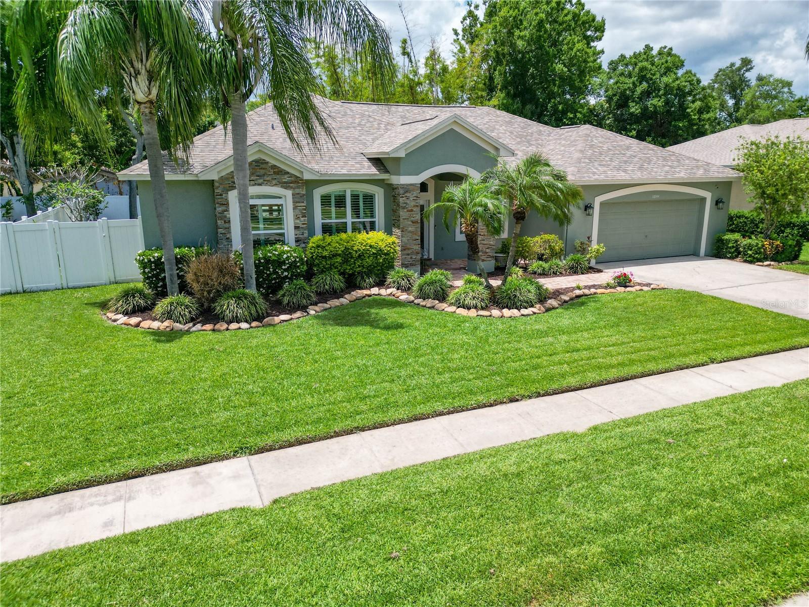 Welcome to a beautifully designed home that blends comfort, style, and the best of Florida indoor-outdoor living—perfectly situated in the heart of Pinellas County and located in a non-flood zone for added peace of mind. From the moment you arrive, the stained glass front entry and inviting curb appeal set the tone for the thoughtful details found throughout the home. Inside, the spacious living areas are filled with natural light and designed for both everyday living and entertaining. Tile flooring paired with 6" baseboards throughout, 9’10” ceilings with crown molding, and custom architectural details including oval archways, built-in display shelving, and a wood accent wall create a warm yet upscale feel. Plantation shutters and large 8' sliding glass doors help bring the outdoors in and create a seamless flow throughout the home. The kitchen is both functional and beautifully updated, featuring Cambria quartz countertops, a large island, soft-close cabinetry, a built-in pantry, stainless steel appliances, and subtle halo lighting. The open layout keeps the kitchen connected to the dining and living spaces, making it ideal for hosting family and friends. The living room is a standout space with a stone-accented electric fireplace, custom built-ins, surround sound, and an 8' fully pocketing triple slider that recesses into the wall, opening the home completely to the outdoor living area and creating the perfect setup for entertaining. The primary suite offers a relaxing private retreat with direct pool access and a showcase arch entry accented by halo spotlighting. In addition to the 6’.2” x 5’.10” walk-in closet, there is also a second closet for additional storage and a built-in wall display shelf. The en-suite bath features dual vanities, a soaking tub framed by plantation shutters, and an oversized walk-in shower with elegant finishes throughout. Additional spaces include well-appointed secondary bedrooms, a dedicated office with double glass entry doors perfect for working from home, and an updated guest bath with a Cambria quartz vanity, designer lighted mirror, and remodeled tub/shower combination. Step outside to your private screened pool area designed for year-round enjoyment. The large 24’ x 13”.8” pool features built-in seating along with an overflowing spa, while the covered patio creates a comfortable space to relax or entertain. The white PVC fully +fenced backyard adds both privacy and functionality. Additional highlights include a spacious inside laundry room with storage and utility sink, a garage with storage cabinetry, and numerous custom upgrades throughout the home. Conveniently located near restaurants, shopping, and everyday conveniences, with a short drive to the airport and the beautiful Gulf beaches, this home offers the perfect combination of comfort, location, and Florida living. This is a home that truly feels welcoming the moment you walk through the door.
