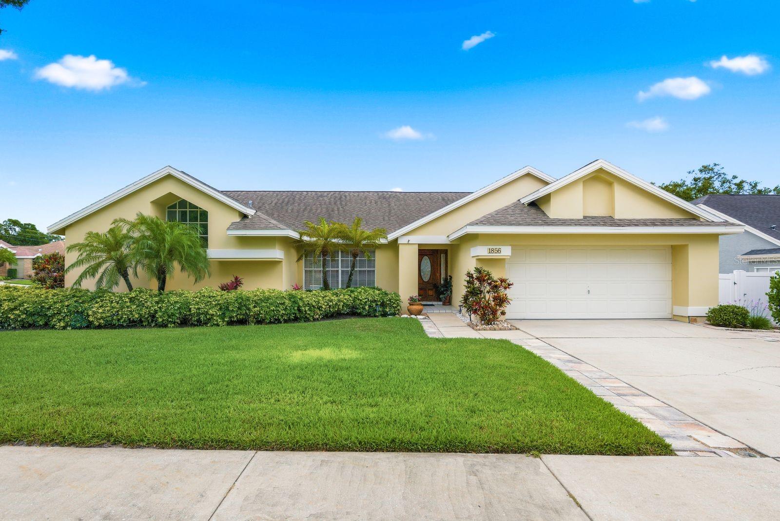 Virtually Staged. Welcome to 1856 Wood Thrush Way in the highly sought-after Pipers Meadow community of Palm Harbor. This beautiful home features 4 bedrooms, 3 bathrooms, a 2 car garage, and a luxurious open pool with spillover spa, all situated on an oversized fenced corner lot. Step through the custom-designed double front doors into a bright and inviting foyer that flows seamlessly into the formal living and dining areas. Vaulted ceilings and a thoughtfully designed open concept split floor plan create a spacious and comfortable feel throughout. The cozy family room features a wood burning fireplace and opens to the kitchen with wood cabinetry, granite countertops, stainless steel appliances, and views of the pool area. Five sets of sliding glass doors provide abundant natural light and pool views from most rooms. The private primary suite is tucked away on one side of the home and features sliding doors leading to the pool, an oversized walk-in closet, and an en suite bath with soaking tub, separate shower, and private commode area. Enjoy Florida living outdoors with a screened patio, built-in bar, pool bath access, and perfectly sized open pool and spa. Additional updates include HVAC 2023, water heater 2023, and roof 2015. Located in Flood Zone X and a non-evacuation zone. Prime location less than 5 miles from Honeymoon Island State Park and minutes to the Pinellas Trail, beaches, shopping, dining, medical facilities, and top-rated schools including Palm Harbor University High School and Palm Harbor Middle School. Pipers Meadow is a well-maintained community with an active social club, offering the perfect combination of luxury, comfort, and convenience.