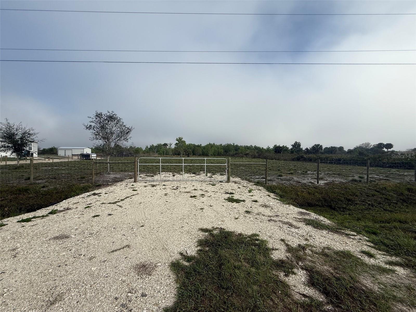 Rare opportunity in Okeechobee! Two adjoining parcels being sold together as one expansive 2.5-acre homesite. Conveniently located just off Peavine Trail, a main paved road, this property offers easy access while maintaining a peaceful, rural setting. Approximately 1.50 acres have already been cleared, saving you time and money. Property features an installed culvert and fenced frontage for added convenience and access. Electricity is available at the street, making it easier to plan your future build or investment. Plenty of room for your custom home, workshop, or recreational use. Don’t miss this versatile land opportunity in a growing area!