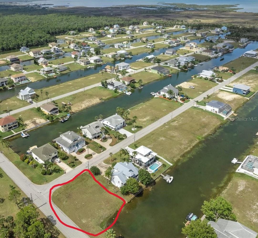 PRICE IMPROVEMENT $63,500. RARE FIND IN HERNANDO BEACH – HURRY! This Oversized Corner Lot, at nearly 7,900 square feet, offers plenty of room for your dream home, especially with the added bonus of canal access and beautiful northern exposures. The views of the common area and fountain would make for a serene and peaceful setting. Being in the deed-restricted community of Hernando Beach South offers additional peace of mind with the homeowners' association maintaining the lawn until construction, as well as providing boat ramp access. Plus, the close proximity to the Weeki Wachee Preserve and its natural beauty is hard to beat. With local restaurants, shops, and popular outdoor destinations like Weeki Wachee Springs just minutes away, it seems like the perfect spot for a coastal lifestyle. Great views possible from a third-story level, which could bring glimpses of both the preserve and the Gulf.