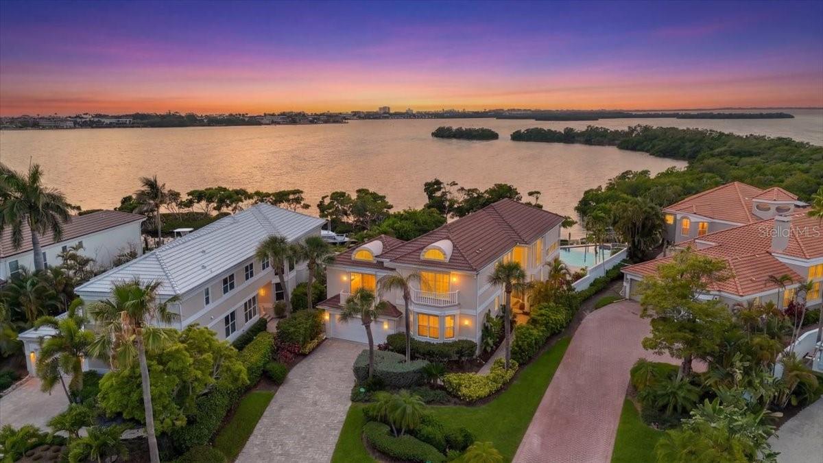 Come for a visit and you will want to stay and make it yours!  Strategically set back from the road, and appropriately positioned on this oversized lot, to allow for an abundance of private waterfront splendor.   The expansive paver patio, with oversized pool, spa, outdoor kitchen, and fully equipped pool bath make this the prime setting for endless entertainment and fun with family and friends.   Bay views expand over the mangroves to the rookeries and night lights of the Key as you take in the setting sun over Buttonwood Harbor.  Get your fishing pole and binoculars ready because enjoyment is an every day event from your dock watching the beautiful Florida feather-life soar thru the skies or dropping a line to hook a surprise catch!  Love the boating life?  Great- your private dock awaits mooring of its next floating occupant!  Upon entry you will be greeted with a customized deco- entry door offset with etched glass above.  Inside this spacious home you will find three en-suite bedrooms with a highly possible 4th en-suite in the loft space.    The interior space offers marble floors thru-out the entire residence, including the striking marble staircase, and ceilings that reach to great heights allowing for transom windows and a wall of glass to incorporate natural lighting and this amazing view.  Like cocktails and eating?  A home hi-lite is the wet bar which can serve multiple purposes- bar, buffet, or even a desk, centrally positioned between kitchen, living, dining and family room areas so that no one is too far from that beloved bartender or the delectable fare!  Love art?  These walls were meant for displaying the finest of your collection.  This is a fabulous floorplan with a very separated bedroom layout providing plenty of space for all to spread out and make themselves comfortable.  Located in Bay Isles, this home offers guarded, gated access and also deeded access to the Bay Isles Beach Club.