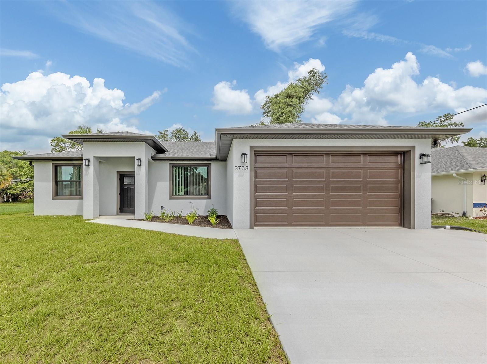 Available for immediate occupancy, this stunning BRAND-NEW custom-built home offers modern design, quality craftsmanship, and the convenience of RARE city water and sewer service.

Thoughtfully designed with a desirable split-bedroom floor plan, this 3-bedroom, 2-bath residence offers 1,500 square feet under air and 2,165 total square feet. Soaring 10-foot ceilings throughout, elegant tray ceiling details, and an open-concept layout create a bright and inviting living space filled with natural light. The interior showcases neutral contemporary finishes, luxury laminate flooring throughout the entire home, and a seamless flow between the living, dining, and kitchen areas.

The designer kitchen is beautifully appointed with white soft-close cabinetry, quartz countertops, ample workspace, and a complete appliance package, making it ideal for both everyday living and entertaining. All appliances are included, along with installed lighting fixtures, ceiling fans, and window treatments, providing a truly move-in-ready experience.

The spacious primary suite offers privacy and comfort, while the split-bedroom design creates an ideal layout for family members and guests. The well-appointed bathrooms continue the home's modern aesthetic with quality finishes and thoughtful design.

Built for durability, energy efficiency, and peace of mind, this home features impact-resistant windows and doors throughout, 5" R-20 spray foam insulation throughout the attic including the garage, a water softener system, gutters surrounding the entire home, and ALL underground utilities, including an underground backflow valve. A dedicated generator inlet allows you to safely connect a portable generator directly to the home's electrical system during power outages. The spacious two-car garage provides additional storage and functionality.

Ideally situated in a quiet North Port neighborhood, this exceptional location places you just minutes from the vibrant downtown of Wellen Park, offering an exciting mix of restaurants, shopping, entertainment, community events, and medical facilities. Nearby golf courses, parks, walking trails, and recreational opportunities make it easy to enjoy the Florida lifestyle. Sports enthusiasts will appreciate the close proximity to CoolToday Park, the Spring Training home of the Atlanta Braves.

Beautiful Gulf Coast beaches, including Manasota Key, are approximately 30 minutes away, offering soft sand, turquoise waters, and world-class sunsets. Convenient access to U.S. 41 (Tamiami Trail) and Interstate 75 provides easy travel to Venice, Sarasota, Punta Gorda, Boca Grande, Fort Myers, and Tampa. Multiple regional airports are also within easy reach for both business and leisure travel.

Located in desirable Flood Zone X, where flood insurance is typically not required by lenders, and with no HOA fees, deed restrictions, or CDD fees, this exceptional new-construction home offers the perfect combination of modern comfort, energy efficiency, premium upgrades, and an outstanding Southwest Florida location.