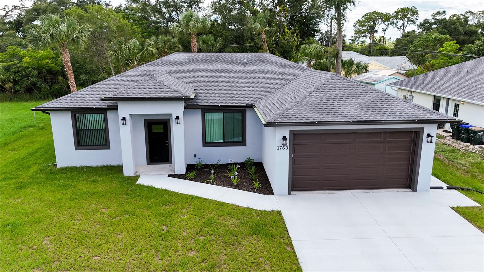 Available for immediate occupancy, this stunning BRAND-NEW custom-built home offers modern design, quality craftsmanship, and the convenience of RARE city water and sewer service.

Thoughtfully designed with a desirable split-bedroom floor plan, this 3-bedroom, 2-bath residence offers 1,500 square feet under air and 2,165 total square feet. Soaring 10-foot ceilings throughout, elegant tray ceiling details, and an open-concept layout create a bright and inviting living space filled with natural light. The interior showcases neutral contemporary finishes, luxury laminate flooring throughout the entire home, and a seamless flow between the living, dining, and kitchen areas.

The designer kitchen is beautifully appointed with white soft-close cabinetry, quartz countertops, ample workspace, and a complete appliance package, making it ideal for both everyday living and entertaining. All appliances are included, along with installed lighting fixtures, ceiling fans, and window treatments, providing a truly move-in-ready experience.

The spacious primary suite offers privacy and comfort, while the split-bedroom design creates an ideal layout for family members and guests. The well-appointed bathrooms continue the home's modern aesthetic with quality finishes and thoughtful design.

Built for durability, energy efficiency, and peace of mind, this home features impact-resistant windows and doors throughout, 5" R-20 spray foam insulation throughout the attic including the garage, a water softener system, gutters surrounding the entire home, and ALL underground utilities, including an underground backflow valve. A dedicated generator inlet allows you to safely connect a portable generator directly to the home's electrical system during power outages. The spacious two-car garage provides additional storage and functionality.

Ideally situated in a quiet North Port neighborhood, this exceptional location places you just minutes from the vibrant downtown of Wellen Park, offering an exciting mix of restaurants, shopping, entertainment, community events, and medical facilities. Nearby golf courses, parks, walking trails, and recreational opportunities make it easy to enjoy the Florida lifestyle. Sports enthusiasts will appreciate the close proximity to CoolToday Park, the Spring Training home of the Atlanta Braves.

Beautiful Gulf Coast beaches, including Manasota Key, are approximately 30 minutes away, offering soft sand, turquoise waters, and world-class sunsets. Convenient access to U.S. 41 (Tamiami Trail) and Interstate 75 provides easy travel to Venice, Sarasota, Punta Gorda, Boca Grande, Fort Myers, and Tampa. Multiple regional airports are also within easy reach for both business and leisure travel.

Located in desirable Flood Zone X, where flood insurance is typically not required by lenders, and with no HOA fees, deed restrictions, or CDD fees, this exceptional new-construction home offers the perfect combination of modern comfort, energy efficiency, premium upgrades, and an outstanding Southwest Florida location.