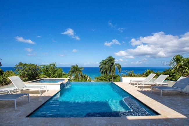 Paradise Found!!  Welcome to Tranquilo, an extraordinary five-bedroom luxury villa perched on a quiet cliffside in the heart of Rincón, offering breathtaking ocean views and the ultimate in Caribbean elegance.

Designed in an open courtyard style, this exceptional residence blurs the line between indoor and outdoor living. At its center, a vanishing-edge pool appears to flow directly into the sea, creating a seamless connection to the horizon. The villa is just 350 steps from the beach and Rincón’s world-famous surf breaks, offering easy access to sand, surf, and sunsets.

Every detail of Tranquilo showcases custom craftsmanship and thoughtful design, from its refined finishes to the artful integration of natural materials. Expansive terraces and open living spaces capture ocean breezes and frame stunning views—perfect for whale watching during migration season or entertaining against the backdrop of fiery Caribbean sunsets.

Located on a quiet, private street, yet just minutes from Rincón’s vibrant dining and surf scene, Tranquilo embodies the ideal blend of luxury, serenity, and tropical lifestyle.