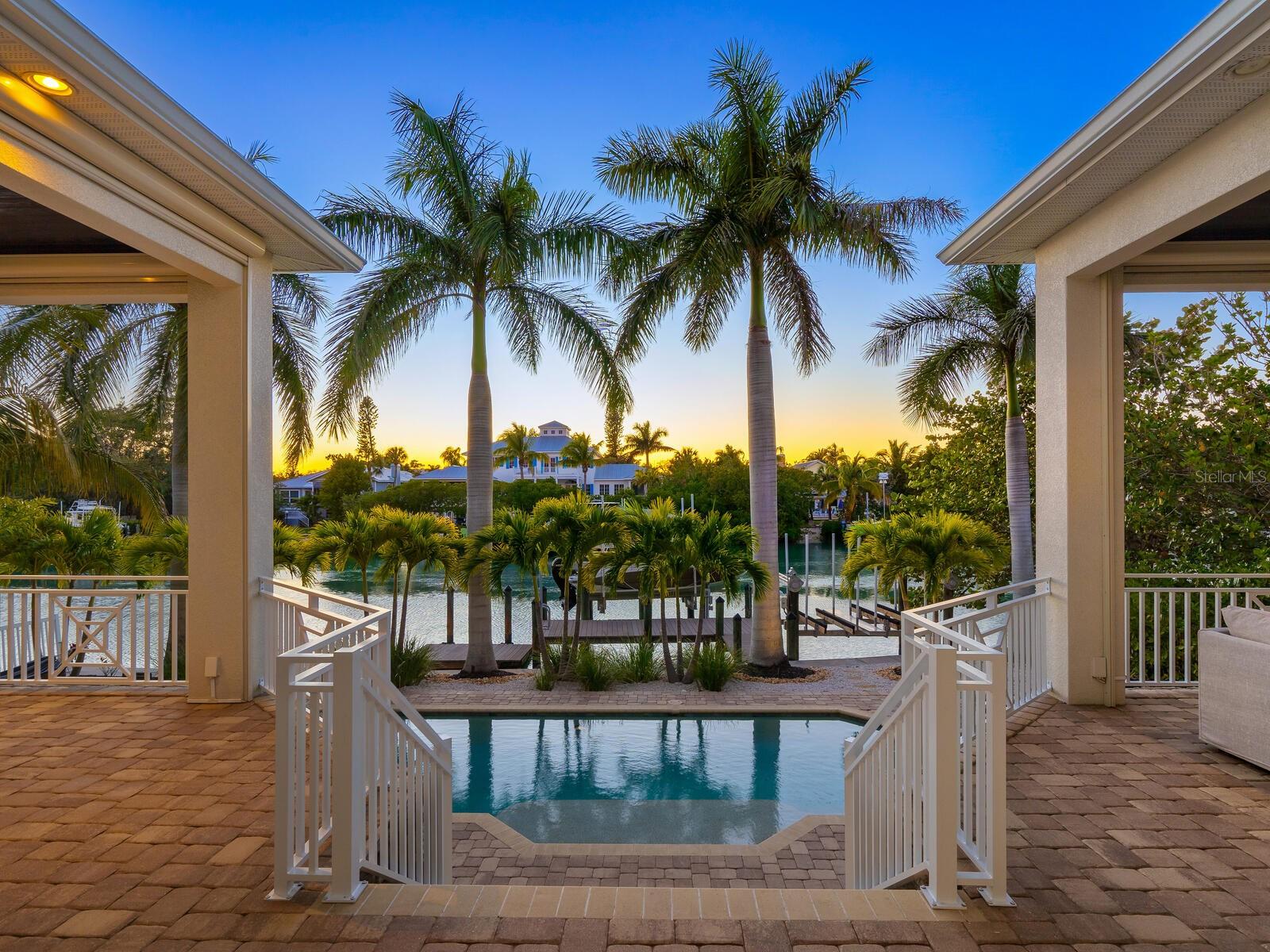 Welcome to 3650 Flamingo Avenue, where luxury waterfront living meets coastal elegance. On the wide, emerald, free-flowing Hansen Bayou with deep sailboat water and no fixed bridges, this home is a boater's dream come true. On desired Bay Island, between Sarasota’s mainland and the north end of Siesta Key, convenience meets luxury in this exceptional property. Upon arrival, you'll be greeted by a grand 23-foot entryway and foyer leading to an open floor plan, where soaring ceilings and wall-to-wall water views set the stage for an unparalleled living experience. Sliding glass doors seamlessly connect indoor and outdoor spaces, inviting you to enjoy two covered balconies, a sparkling pool surrounded by a paver deck and conversation fire pit, an entertainer's paradise. The heart of the home, the great room, is anchored by a cozy gas fireplace, while the open-island kitchen boasts solid-wood Shaker cabinets, quartz countertops, and top-of-the-line stainless steel appliances including a six-burner Viking stove, Sub-Zero refrigerator and Bosch dishwasher. The spacious walk-in pantry ensures ample storage, while the breakfast bar invites casual gatherings. With two fabulous primary suites, one on each floor, luxury knows no bounds. Each suite features spacious walk-in closets, luxurious en-suite baths and tranquil water views, offering unparalleled serenity. A private guest suite on the mezzanine level ensures comfort and privacy for visitors. The expansive upstairs bonus room serves as a hub for the upper level with a wall of closets for extra storage and a wall of windows to enjoy water views, while two additional second level bedrooms share a bath and boast walk-in closets. Outside, the entertainment continues with open lanais ideal for dining al fresco and savoring spectacular Siesta Key sunsets. Take a dip in the sparkling pool, unwind by the gas fire pit or embark on aquatic adventures from your dock, complete with a jet ski lift, 10,000-pound boat lift and floating dock. Whether fishing, paddleboarding, kayaking or simply watching dolphins play, the possibilities are endless. Tropically landscaped grounds, a circular paver drive and a durable metal roof add to the allure of this coastal oasis. Experience the epitome of coastal living at its finest, where every day feels like a vacation in paradise. Welcome home to 3650 Flamingo Ave. where luxury, convenience and natural beauty converge in harmony. Bedroom Closet Type: Walk-in Closet (Primary Bedroom).