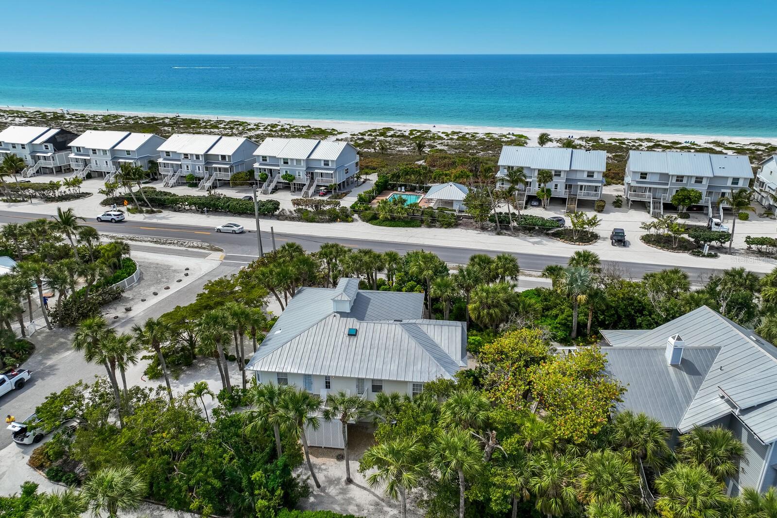 A true gem! This charming 4-bedroom, 2-bathroom home with over 2,500 square feet in the Golden Beach subdivision is just across the street from the beach. There is only a short distance to The Historic Boca Grande Village for shopping and restaurants. Kidd Street holds only 3 other homes making it your own private oasis. Experience breathtaking sunset views from your oversized screened lanai facing the gulf. The main floor features hardwood floors, a bright airy floor plan, a living room, dining room and kitchen. The master bedroom suite is off the living room featuring an oversized closet and bathroom. The two spare bedrooms have a jack-n-jill bathroom with the laundry closet off the hall. The 4th bedroom is in the lower level offering a private entrance for guests. The garage holds 4+ cars and golf carts. The surrounding tropical landscaping on this oversized corner lot provides a tropical getaway. This home offers the true Old Florida lifestyle.