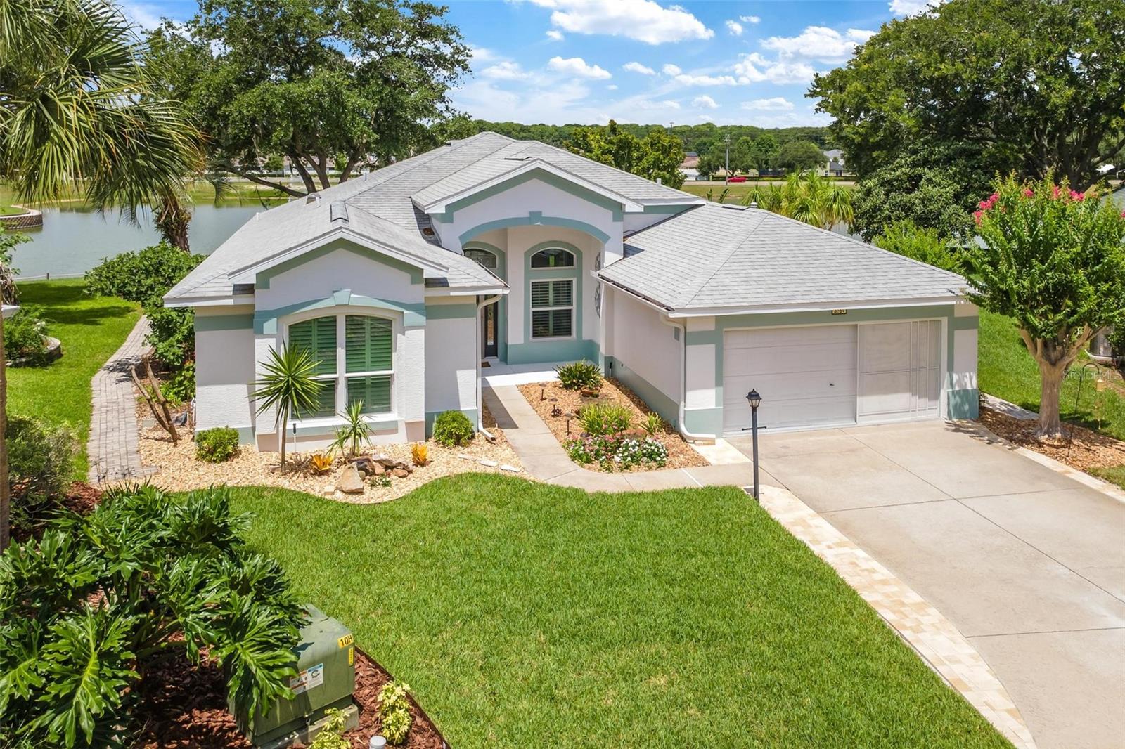 Rare opportunity to own one of Royal Harbor’s most coveted lakefront homes! Located in the gated 55+ waterfront community of Royal Harbor on Little Lake Harris, part of the renowned Harris Chain of Lakes, this beautifully updated residence is perfectly positioned on picturesque Lake Laemont, a peaceful interior lake within the community, offering sweeping water views, a graceful fountain, breathtaking sunsets, and an ever-changing parade of Great Blue Herons, Egrets, and Ibis. Thoughtfully designed to maximize the beauty of its surroundings, this impeccably maintained home offers 2 Bedrooms, 2 Baths, and a private Den/Office with French Doors in a desirable Split Bedroom floor plan. Volume Ceilings, abundant windows, Plantation Shutters throughout, and soft neutral décor create a bright, welcoming atmosphere filled with natural light. The spacious Living Room opens through sliding glass doors to the expansive screened Florida Room with vinyl windows, allowing you to enjoy the fresh Florida breeze or enclose the space for added comfort when desired while taking in the peaceful views of Lake Laemont. Just beyond, a Paver Patio provides the perfect place to grill, entertain, relax, or simply enjoy the tranquil waterfront setting. The beautifully updated Kitchen features Quartz Countertops, quality appliances, a convenient Breakfast Bar, and a Solar Tube that fills the room with natural light. The adjoining Breakfast Nook, surrounded by windows, is the perfect place to begin your day while overlooking beautiful Lake Laemont. The Primary Suite is a peaceful retreat featuring lake views, new carpet, and an updated En-Suite Bath with Quartz Countertops, dual sinks, beautifully renovated Walk-In Shower, and a jetted Garden Tub. The Guest Bedroom also features new carpet. Rich Armstrong laminate flooring extends throughout most living areas, while tile flooring enhances the Florida Room and Baths. Beautiful mature Oaks, colorful specimen plantings, and meticulously maintained landscaping surround the home, while a Paver Walkway encircles the property, enhancing both beauty and convenience. Recent improvements include Impact-Rated Argon Gas Windows (2022), Roof (2020), and A/C (2017). New in 2026: Interior professionally repainted in soft designer colors, Exterior Trim repainted, New Bedroom Carpet, extensive Landscape enhancements, Painted Garage Walls and Floor, widened Driveway with additional Pavers, and beautiful Built-In Dining Room Storage Closets. Royal Harbor residents enjoy a Resort-Style Clubhouse, Heated Pool & Spa, Fitness Center, Social Hall, Library, Craft Room, Billiards, Tennis, Pickleball, Shuffleboard, Bocce, Community Dock, Walking & Biking Paths, Community Garden, RV & Boat Storage, and an active calendar of clubs, events, and social activities. Whether you’re seeking relaxation, recreation, or wonderful new friendships, you’ll discover why so many are proud to call Royal Harbor home.
