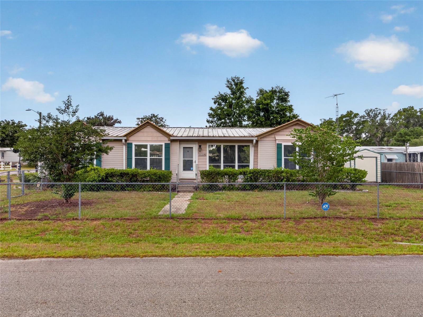Charming 1985 Doublewide in the Heart of Belleview, FL
Spacious, inviting, and perfectly located, this well-kept 1985 doublewide offers a comfortable lifestyle right in the center of Belleview. The large living room welcomes you with a cozy gas fireplace and beautiful bay windows that fill the space with natural light. A second set of bay windows brightens the dining room, creating an airy, open feel throughout.

The generous kitchen provides abundant prep space—ideal for anyone who loves to cook or entertain. Outside, the carport doubles as a patio, giving you flexible outdoor living options, while the screened porch offers a peaceful spot to relax year-round.

Sitting on a fenced corner lot, the property includes a powered workshop, perfect for hobbies, storage, or projects. It’s a well-designed setup.

You’ll be just minutes from Ocala and The Villages, making shopping, dining, and medical services incredibly convenient. And if you love the outdoors, you’re in the right place—Marion County is one of Florida’s top destinations for ecotourism, with its rivers, lakes, forests, and scenic trails. Belleview sits right in the middle of it all. New roof 2025