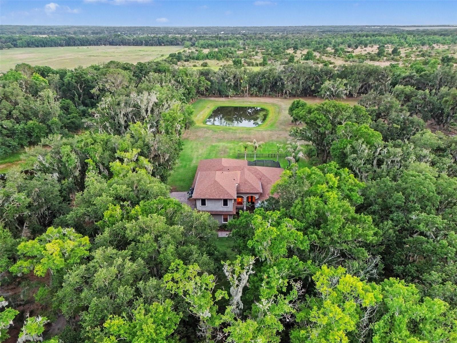 Never before seen on the market, this custom-built, one-owner estate offers over 5.5 completely secluded acres. Perfectly nestled between Alderman’s Ford Conservation Park and Alafia River State Park, the endless miles of the Alafia Nature Preserve sit directly beyond your southern property line. This gives you the tranquil, transportive feel of living on hundreds of acres of untouched Old Florida. Watch breathtaking sunsets reflect over private ponds and lush, mature landscaping on one of the most unique properties in Lithia.
The entire main floor of the home and the steel building are backed by a whole-house standby generator with a 250-gallon propane tank and integrated well-pump backup for complete off grid capability. Additional infrastructure includes two new AC units (2021), a 3-car garage with electric vehicle (EV) charging hookups, a well-fed irrigation system, and a brand-new interior Reverse Osmosis whole-home water filtration system. The estate features a massive(30x50) detached steel building on a reinforced slab with dedicated electric.

Inside, the contemporary custom residence boasts soaring ceilings, extra-tall doors, and elegant crown molding throughout. The dedicated media wing features a fully equipped movie theater complete with seating, new carpeting, and custom drapes, alongside a professionally sound-treated recording studio room. Live effortlessly in the expansive screened lanai, featuring an outdoor grilling station, custom bar area, and a peaceful, custom-filtered Koi pond. As an added bonus, the half-bath is already pre-plumbed for an easy full-bath conversion. Topped with a premium "Desert Rose" roof by TOSCA, this turn-key powerhouse offers instant equity and is ready for its next adventure. Full house generator and EV charger. Schedule your private tour today!