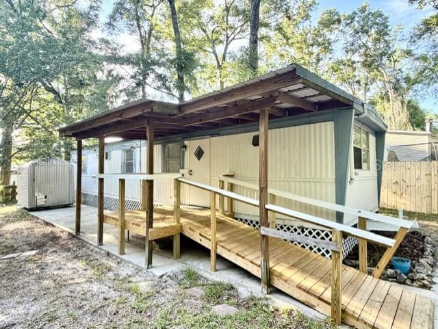 Charming and affordable home in the heart of High Springs! Situated on a spacious quarter-acre lot at the end of a quiet street, this 2-bedroom, 1-bath home offers privacy and a peaceful setting surrounded by mature shade trees. A full roof-over provides protection for the home and creates a covered outdoor patio area, perfect for relaxing, entertaining, or enjoying Florida’s beautiful weather. Improvements include a newer central HVAC system, a new wooden covered front deck and ramp, adding both convenience and curb appeal, as well as a fresh coat of paint on the walls and on the wood kitchen cabinets for an updated interior touch. The kitchen also features a tile-top breakfast bar with seating, creating a welcoming space for casual dining and gathering. A brand-new wood privacy fence on one side of the property enhances the secluded feel of the backyard. The property also includes a metal utility shed, providing valuable storage space for tools, equipment, or hobbies. Whether you’re looking for a starter home, investment property, or a low-maintenance retreat near the natural springs and attractions of High Springs, this property offers plenty of potential in a desirable location.