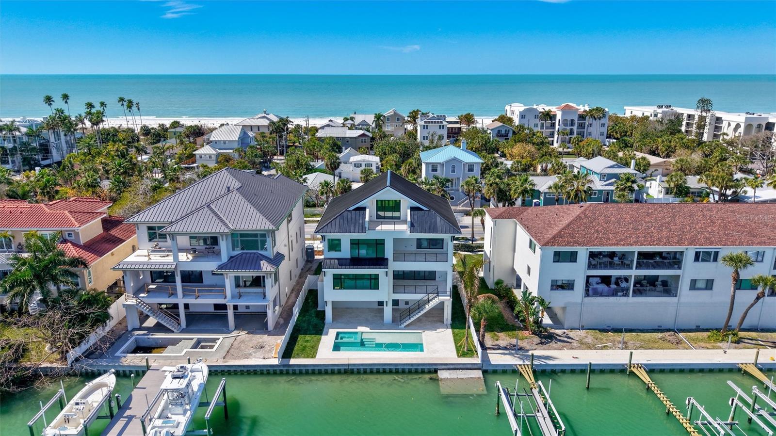 New Construction Waterfront Living in Pass-a-Grille. A rare opportunity to own new construction waterfront in Pass-a-Grille—without the compromises of renovating older coastal homes.  This home is designed for those who value effortless ownership and delivers a true lock-and-leave lifestyle just moments from the sugar-white sands of St. Pete Beach. Wake to breathtaking sunrises over the Intracoastal Waterway and unwind with Gulf sunsets from expansive elevated terraces—an everyday rhythm that defines life here. Built with concrete and block construction throughout, the home offers exceptional structural integrity and long-term peace of mind—an increasingly rare advantage along the beaches.
Inside, a refined coastal palette blends wide-plank wood flooring, custom cabinetry, and designer finishes to create a space that feels both elevated and relaxed. The chef’s kitchen, complete with premium appliances and natural stone surfaces, opens seamlessly to the main living areas—ideal for entertaining or simply enjoying the waterfront backdrop.
Designed to embrace indoor-outdoor living, multiple terraces extend the living space outward, while below, a private resort-style setting awaits. The custom saltwater pool and spa—complete with sun shelf and lap area—create the perfect setting for hosting, relaxing, or returning from a day on the water.
Additional features include a private elevator, impact-rated windows and doors, advanced climate systems, and integrated smart home technology—ensuring comfort, security, and ease whether you're in residence or away. 
New construction. Waterfront. Walkable beach lifestyle.
A rare combination in Pass-a-Grille—offering a level of convenience, durability, and design that older homes simply can’t match.