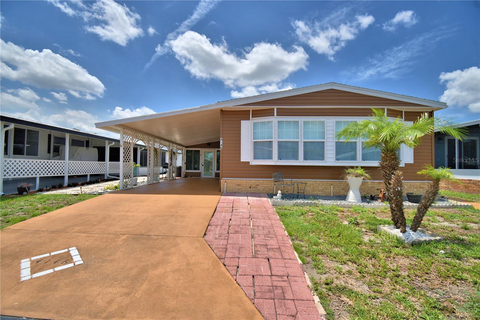You won't want to miss this opportunity.  This 1344 sf home located in Oakwood Estates, a 55+ community.  From the carport walk into the  lanai, perfect for entertaining.  From there step through the French doors into the open and inviting home with an open and updated kitchen with newer appliances including a cooktop, built in double ovens, built in microwave, and nice sized refrigerator.  Past the kitchen you will see the comfortable dining area with built in cabinetry.  Then follow through to the spacious living room with more built in cabinets.  Returning back through the kitchen you will find the family room area which is open to the kitchen, just perfect for those family and friends get togethers.  The main bathroom has been updated with a beautiful shower and updated stool.  The guest bedroom is attached to this bath.  At the back of the home you will find the primary bedroom complete with two built in closets and a nice sized bathroom attached.  The shingled room was installed in 2025 and the air conditioner and water heater were installed in 2021.  Oakwood Estates offers many amenities as well as activities.  You can join in on the activities or just sit back and watch the world go by.