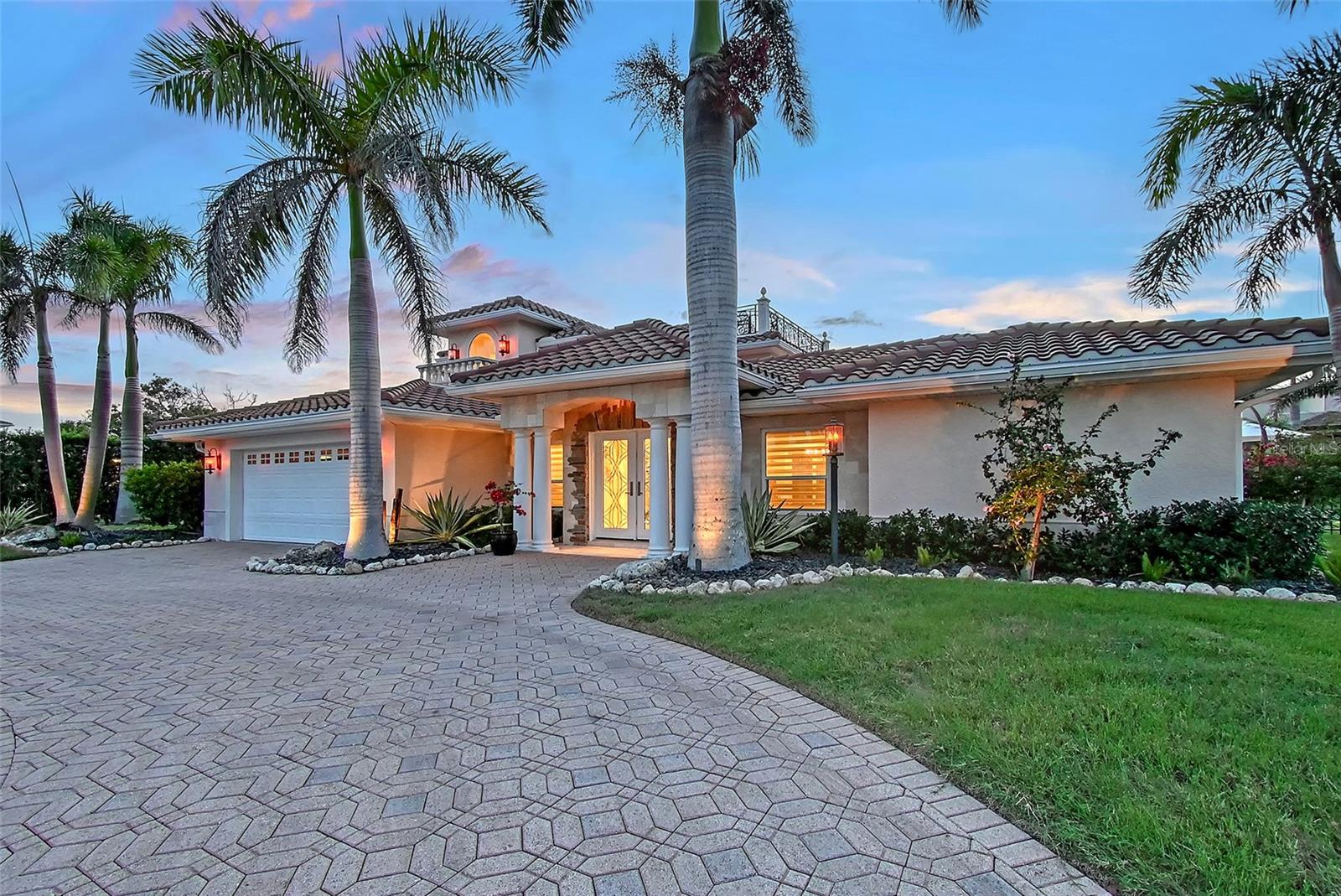 Country Club Shores at its finest. Three homes in from the bay. Attention to detail has created a spectacular updated home, featuring a newer kitchen and appliances, porcelain tile in two bedrooms, newly refinished marble flooring in common areas and baths, custom light fixtures, doors, and trim, along with crown molding. The home is finished with updated high-impact windows and sliders. The details have been extended to the finely appointed, updated baths, featuring marble counters throughout. A wet bar with an ice maker, conveniently just off the family room, makes an excellent feature for you and your guests. A main floor office in addition to two guest bedrooms, one with an en-suite bath, with an abundance of built-ins, with access to the pool and spa, and the other with private access to the full guest bath. The second level features a private primary suite oasis, complete with a balcony and a rooftop terrace, accessed by a spiral staircase offering views of the canal, spectacular sunrises, sunsets, and the Intracoastal Waterway. The primary bath comes complete with double sinks imported from Italy, a claw tub, and a separate shower. If you're looking for a custom walk-in closet, look no further - this home features one. The home features an additional fuel source, a 250-gallon propane tank, which provides gas cooking on the five-burner countertop kitchen range, heating for the hot water tank and spa, and is also roughed in for use on the rooftop terrace. Both the saltwater pool and spa underwent remodeling, featuring the added luxury of shallow pool lounging and flowing water fountains. The garage features its mini-split air conditioning unit, enabling you to work extended hours on projects. The dock comes complete with a 20,000-pound boat lift, a jet ski lift, electricity, and a jet ski port. The inspiring exterior custom lighting transforms the day into an evening of soft flickering glows with accents of palm trees, landscaping, and architectural splendor. Luxury has no boundaries in this renovated, finely appointed canal-front home, with deeded beach access just across the Gulf of Mexico Drive at the crosswalk. South of Publix, CVS, banks, places of worship, public tennis, and a short drive to St. Armands Circle, along with Sarasota and all it offers.