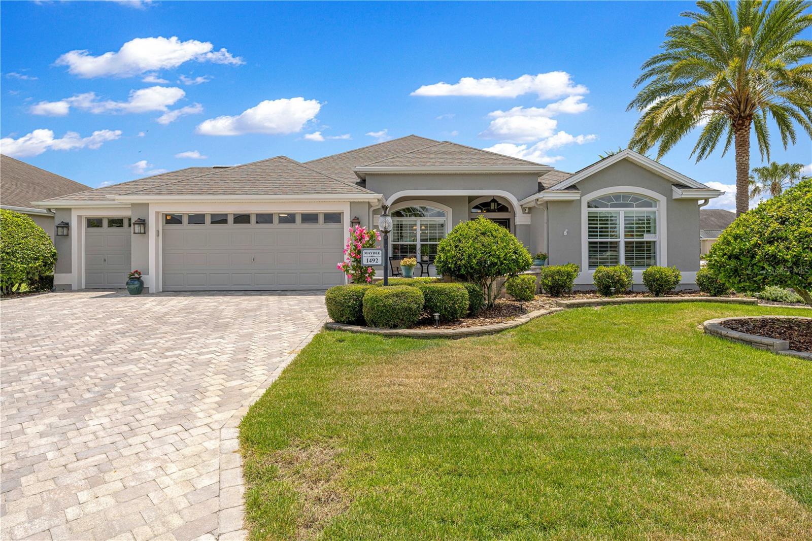 **GARDENIA MODEL** **VILLAGE OF GILCHRIST** **GOLF CART GARAGE** **GLASS-ENCLOSED LANAI** ** MUST SEE- BONUS SCREEN ROOM WITH BULLFROG HOTTUB (2026)** **HVAC 2024** **CORNER LOT**  Welcome to the highly sought-after VILLAGE OF GILCHRIST, where timeless elegance, exceptional privacy, and thoughtful upgrades define this beautifully maintained GAREDNIA MODEL. Perfectly positioned on a desirable corner homesite with a coveted north-facing front exposure, this stunning residence offers impressive curb appeal with a paver brick driveway, front patio, and lush professional landscaping that creates an inviting first impression.

A rare 2½-car garage provides ample room for two vehicles and a golf cart, while a built-in workbench and cabinetry making it the perfect space for hobbies, projects, and additional storage. Modern smart-home features include a Ring Doorbell Pro, front porch and rear walkway cameras, a Kwikset Wi-Fi smart lock system, and a MyQ smart garage door opener for convenience and peace of mind.

Step inside to discover a bright, open floor plan enhanced by neutral tile flooring throughout the main living areas, elegant crown molding, plantation shutters, and an abundance of natural light. The beautifully appointed kitchen is designed to impress, featuring granite countertops, a matching granite backsplash, and a full suite of updated stainless steel appliances, creating the perfect setting for both everyday living and entertaining.

The spacious primary suite serves as a private retreat, complete with dual walk-in closets, double vanities, granite countertops, and a luxurious Roman shower. Guests will appreciate the beautifully remodeled guest bath showcasing an Onyx sink and countertop, designer wave-tile shower walls, upgraded shower flooring, and stylish California sliding glass barn doors.

One of the home's most impressive features is the expansive glass-enclosed lanai, offering year-round comfort with tile flooring, pull-down shades, and a Mitsubishi mini-split air conditioning system. Whether enjoying your morning coffee or entertaining guests, this space seamlessly extends the home's living area. Just beyond, a private screened pergola retreat awaits, featuring a Bullfrog hot tub and tranquil surroundings that create your own personal resort-style escape.

The outdoor setting is truly exceptional, with mature landscaping and a substantial privacy hedge separating the property from the rear neighbor, creating a peaceful and secluded backyard environment rarely found in The Villages.

Additional enhancements include a new main house HVAC system installed in 2024, a Nova Filter Plus water filtration and softener system, updated appliances throughout, and countless thoughtful upgrades that elevate everyday living.

Combining luxury finishes, modern technology, exceptional privacy, and an unbeatable location in one of The Villages' most desirable neighborhoods, this remarkable Gardenia model offers the Florida lifestyle you've been waiting for. This home will not last long, schedule a private showing today to see this dream yourself!