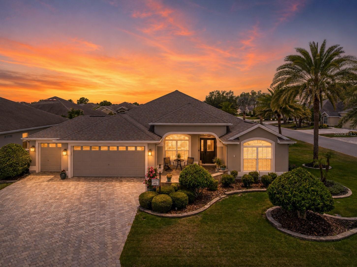 **GARDENIA MODEL** **VILLAGE OF GILCHRIST** **GOLF CART GARAGE** **GLASS-ENCLOSED LANAI** ** MUST SEE- BONUS SCREEN ROOM WITH BULLFROG HOTTUB (2026)** **HVAC 2024** **CORNER LOT**  Welcome to the highly sought-after VILLAGE OF GILCHRIST, where timeless elegance, exceptional privacy, and thoughtful upgrades define this beautifully maintained GAREDNIA MODEL. Perfectly positioned on a desirable corner homesite with a coveted north-facing front exposure, this stunning residence offers impressive curb appeal with a paver brick driveway, front patio, and lush professional landscaping that creates an inviting first impression.

A rare 2½-car garage provides ample room for two vehicles and a golf cart, while a built-in workbench and cabinetry making it the perfect space for hobbies, projects, and additional storage. Modern smart-home features include a Ring Doorbell Pro, front porch and rear walkway cameras, a Kwikset Wi-Fi smart lock system, and a MyQ smart garage door opener for convenience and peace of mind.

Step inside to discover a bright, open floor plan enhanced by neutral tile flooring throughout the main living areas, elegant crown molding, plantation shutters, and an abundance of natural light. The beautifully appointed kitchen is designed to impress, featuring granite countertops, a matching granite backsplash, and a full suite of updated stainless steel appliances, creating the perfect setting for both everyday living and entertaining.

The spacious primary suite serves as a private retreat, complete with dual walk-in closets, double vanities, granite countertops, and a luxurious Roman shower. Guests will appreciate the beautifully remodeled guest bath showcasing an Onyx sink and countertop, designer wave-tile shower walls, upgraded shower flooring, and stylish California sliding glass barn doors.

One of the home's most impressive features is the expansive glass-enclosed lanai, offering year-round comfort with tile flooring, pull-down shades, and a Mitsubishi mini-split air conditioning system. Whether enjoying your morning coffee or entertaining guests, this space seamlessly extends the home's living area. Just beyond, a private screened pergola retreat awaits, featuring a Bullfrog hot tub and tranquil surroundings that create your own personal resort-style escape.

The outdoor setting is truly exceptional, with mature landscaping and a substantial privacy hedge separating the property from the rear neighbor, creating a peaceful and secluded backyard environment rarely found in The Villages.

Additional enhancements include a new main house HVAC system installed in 2024, a Nova Filter Plus water filtration and softener system, updated appliances throughout, and countless thoughtful upgrades that elevate everyday living.

Combining luxury finishes, modern technology, exceptional privacy, and an unbeatable location in one of The Villages' most desirable neighborhoods, this remarkable Gardenia model offers the Florida lifestyle you've been waiting for. This home will not last long, join us for our openhouse or schedule a private showing today to see this dream yourself!