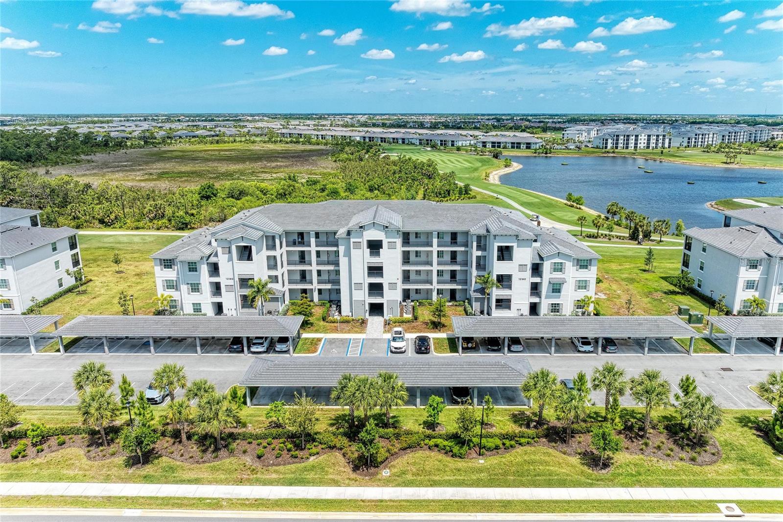 Enjoy some of the best views in the community from this beautifully appointed third-floor Birkdale Model, offering panoramic vistas of holes 1 & 10, a large lake, and the practice facilities—there’s always something scenic and entertaining to take in. Offered TURNKEY FURNISHED, this condo is truly move-in ready. RARE BONUS: 2 GOLF MEMBERSHIPS INCLUDED Inside, the open-concept layout is bright and inviting, with a stylish kitchen featuring quartz countertops, shaker-style cabinetry, custom backsplash, and upgraded lighting. The kitchen flows seamlessly into the living and dining areas, creating the perfect space for both everyday living and entertaining. Enjoy peaceful mornings with coffee while watching golfers tee off from your dining area.

The split-bedroom floorplan provides ideal privacy, with a spacious primary suite boasting two walk-in closets and a well-appointed ensuite bath with quartz counters and a tiled shower. The guest bedroom is conveniently located near a second full bath, making it perfect for visitors or a flexible dual-suite setup.

Additional features include elevator access, a designated carport, ample guest parking, and a private storage closet. 
The HOA that covers nearly everything except electricity—water, sewer, cable, internet, exterior maintenance, gated entry, and access to resort-style amenities creating easy living in a resort style community! 

Located in Wellen Park Golf & Country Club, residents enjoy an 18-hole course, resort-style pool & spa, tiki bar, fitness center, pickleball, tennis, bocce, dog park, and more, with a future clubhouse on the way. All just minutes from CoolToday Park, Wellen Park’s vibrant town center, shopping, dining, and Gulf beaches.

Experience the best of golf and resort-style living—schedule your private showing today!