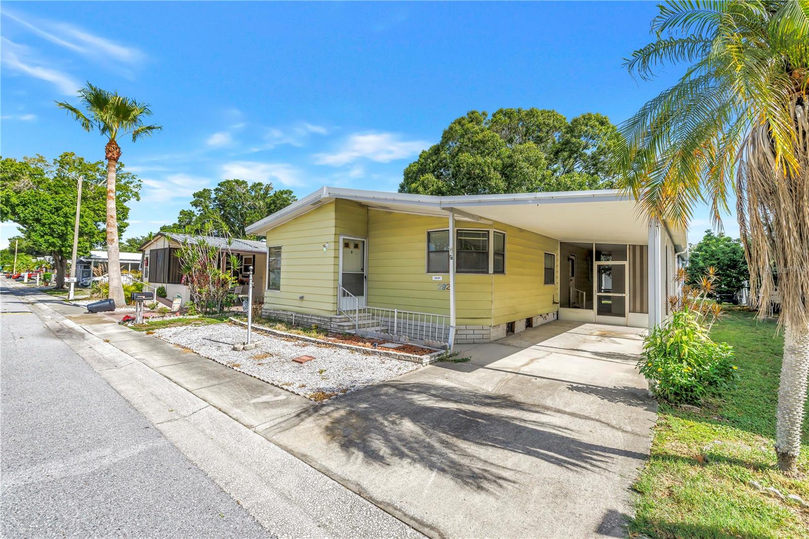 GREAT LOCATION - Move in Ready - 2-bedroom, 2-bath home in the highly desired 55+ community of Paradise Island Co-Op. This home is an AMAZING VALUE – Home is being sold WITH the Co-Op share. Not all homes in this community have shares and must pay lot rent on top of monthly fee. This home sale INCLUDES the co-op share valued over $55,000. All rooms are generously sized, both bedrooms feature walk-in closets, the primary en-suite bathroom features a walk-in shower, and tons of countertop space. The 2nd bedroom also features an en-suite bath access, with a tub shower combo. The kitchen showcases TONS of cabinets and an eat-in breakfast bar. Chores are a breeze with the inside laundry room with storage cabinets. Private driveway with carport accommodates two vehicles. The all-season/Florida room and a workshop/storage area allows for all your storage or tinkering needs. Community clubhouse has a variety of activities including shuffleboard, bocce, horseshoes, pool tables and the pool and spa are heated for your year-round enjoyment. Pet and rental friendly. Close to restaurants, shopping and award-winning beaches. HIGH AND DRY, X flood zone location gives peace of mind. Low HOA fee includes lawn care, Water, Sewer, Trash, Cable and Internet, SAVES YOU MONEY $$!!
