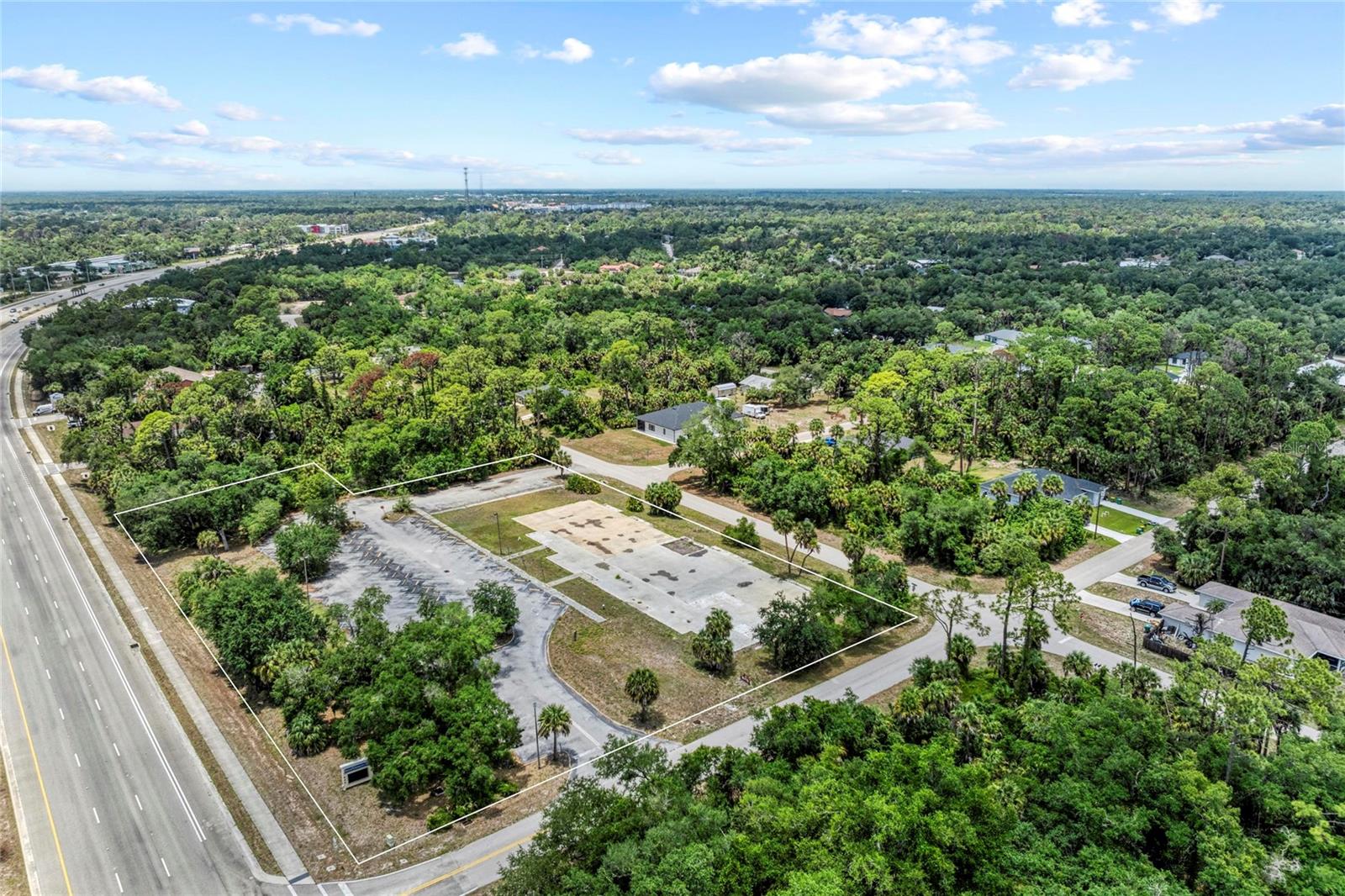 General Commercial Re-Development Site: 2.21 Acres on Tamiami Trail. Eliminate infrastructure delays and save thousands in impact fees with this high-visibility, shovel-ready 2.21-acre commercial parcel. Located at the high-traffic intersection of Tamiami Trail and Camrose Street, this prime lot is a builder’s blank canvas, perfectly optimized for strategic investors, commercial developers, or owner-users looking to break ground immediately. Unlike standard vacant land, this premium parcel comes packed with significant infrastructure already in place, drastically reducing capital expenditure and shortening your timeline for occupancy. Includes a robust, existing 15,000+ sq ft concrete slab on site, built to easily support your structure. Engineered and cleared to accommodate a commercial footprint up to 20,000 sq ft. Comes with existing, transferable stormwater retention infrastructure designed for up to a 20,000 sq ft building. Sits securely at 14.5 feet above sea level and is completely located within Flood Zone X, eliminating mandatory federal flood insurance requirements. Public utilities are already capped and ready for immediate connection, alongside high-capacity 3-phase electric on site. Includes a paved parking lot with 70+ existing spaces (with physical footprint potential for more), and lot lighting. Features a dedicated, separate deep well on site to keep landscaping irrigation costs to a minimum. This parcel commands premier frontage along Tamiami Trail, an expanding commercial corridor known for its heavy daily vehicle traffic (38,000 VPD) and strong sub-market growth. Surrounded by residential development and national commercial anchors, a new development here steps directly into a built-in, consumer base. Schedule your showing today!