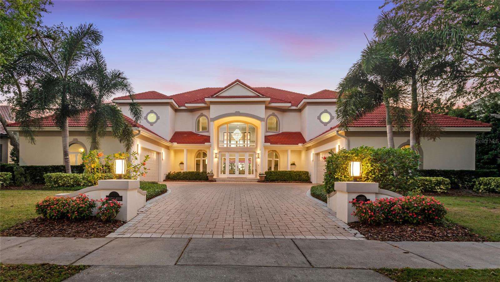 Set within the guard-gated community of Keene’s Pointe, this golf course front residence offers sweeping views across the fairway to Lake Burden just beyond, creating one of the rarest and uninterrupted backdrops in all of Windermere. Walls of glass draw in natural light and keep the scenery front and center throughout the home. In the evenings, the sun settles over the lake, casting warm reflections across the water and fairway, creating an ever changing backdrop enjoyed from both inside and out. As night falls, Disney fireworks complete the view. Designed for modern living, the home features two full bedroom suites on the main level, ideal for multi-generational living, guests, or options for office space. The open kitchen anchors the home and flows seamlessly into the family room and lanai, making it equally suited for entertaining and everyday life. Viking appliances, dual farmhouse sinks, a pot filler, and a generous center island create a chef-driven layout without sacrificing style. Indoor and outdoor living blend effortlessly as sliding glass doors open to a resort style setting. The backyard is anchored by a custom pool with sun shelf, spillover spa, fire features, and water elements, all surrounded by expansive pavers and lush landscaping. A covered lanai offers multiple lounge zones, a summer kitchen with built in grill and beverage refrigerator, ceiling fans, and an open air shower, all positioned to maximize sunset views over the lake. The upper level serves as a private retreat. Enjoy elevated views of the golf course and Lake Burden from your second story primary bedroom which includes a spa inspired bath with freestanding tub, oversized shower, dual vanities, and a boutique style closet. Two additional bedroom en-suites, massive media room with fireplace, and extended balcony provide flexibility for relaxation or work from home living. A split four car garage offers epoxy flooring, EV charging, and climate control adds modern convenience, while thoughtful upgrades throughout make the home truly turnkey. This is a rare opportunity to own a lake and golf front home in Windermere where the view, the floor plan, and the lifestyle align.