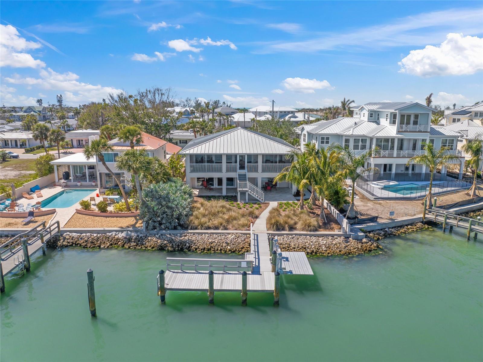 VENICE ISLAND WATERFRONT OASIS ON ROBERTS BAY. Welcome to your dream home on Venice Island, ideally situated on Roberts Bay with direct access to the Intracoastal and Gulf—no bridges! Just steps to the beach, South Jetty, Venice Yacht Club, and all the charm of island living. Hop on your golf cart and cruise to nearby restaurants, boutiques, the grocery store, and entertainment venues with ease.
The main living area is elevated on the upper level, offering panoramic bay views and an open floor plan that flows seamlessly. The covered porch is perfect for outdoor lounging and entertaining while taking in the views. Enjoy hickory engineered flooring, three spacious bedrooms, and two full bathrooms where the primary suite offers a private escape with breathtaking water views, lanai access, a walk-in closet, and ensuite bath.
The lower level offers incredible flexibility with a complete multigenerational living space/in-law suite, including a separate bedroom, full bath, living room, kitchen with breakfast area, lanai, private entrance and more stunning views!
This home includes impact-resistant windows and sliders, a durable metal roof, spray foam insulation and LED lighting for energy efficiency while providing peace of mind. 
Enjoy the added convenience of storing your cars, toys, etc in the 4-car tandem garage. The possibilities are endless as there’s room for a pool and  an elevator can be added if desired.
From your own backyard, take in the spectacular 4th of July fireworks, Christmas boat parade, and daily dolphin shows—a true waterfront lifestyle experience!
This is a rare opportunity to own a true gem in one of the Gulf Coast’s most coveted locations. 3D Tour, Floorplan and Video Available.