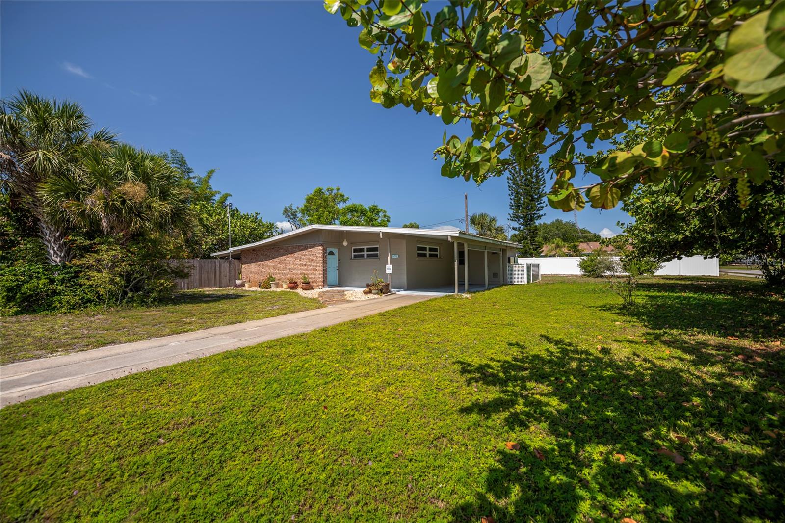 There is so much to say & feel about this amazing home & property situated on a corner, double lot! Step inside and experience the beauty of the terrazzo floors, remodeled kitchen and incredible charm of this 3-bedroom, 2 bath home, open floor plan home that also offers an interior office, plus a den/studio office which spills onto the wraparound covered, enclosed garden patio area. Awesome closet and storage in this remarkable home that includes a laundry room and lots of upgrades throughout. Under 2-year A/C, NEW hot water heater, metal roof, fully paid solar panels, replaced main electrical panel and much more! You will feel the peace & tranquility of this home the minute you open the door, then revisit that feeling as you walk thru the gardens, stopping a moment to enjoy the deep goldfish pond AND wait until you see the THREE sheds: one even features a pull-down staircase for attic storage. The foliage, including fruit, shade, and bamboo trees feature a retreat for your soul. There is also a shallow, irrigation well on site. Fully fenced and gated side lot for your toys, trucks, hobby stuff... bring your boat as the Harbour Heights County park is right around the corner with public amenities including day docks, boat ramp, fishing pier, playground, tennis, basketball, shuffleboard, picnic tables, covered pavilion, grills ... a super home in a super location for major highway accessibility, schools, shopping, day trips to the beach, restaurants, you name it. Call today and see for yourself why the sellers had such difficulty making the decision to sell.