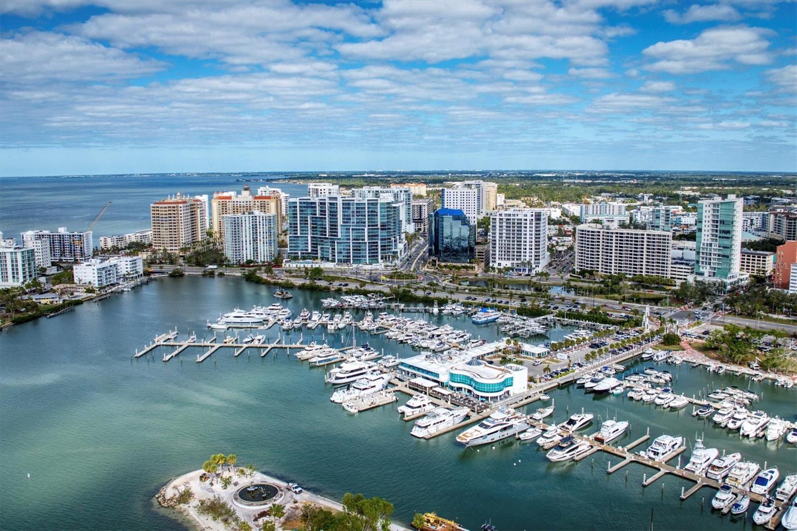 A private residence at The Vue is an entrée to the extraordinary waterfront lifestyle of downtown Sarasota. The inspiring vistas from this exquisite, updated condominium are equally matched by the subtle sophistication of its contemporary interior style and design. From your private elevator foyer, you are immediately welcome to a fabulous view. The generous great room is filled with natural light from the floor-to-ceiling glass and open to a full-length balcony 48’ x 10’.  Beautiful wood floors throughout, except for the 2 back bedrooms, the gourmet kitchen features a large island with quartz countertops, induction cooktop, European white cabinetry, beautiful backsplash, and lots of storage. A custom “cloud” ceiling and a wall unit, designed by a local artist, add a unique touch of elegance in the living room. The primary bedroom has this incredible view, a luxurious bathroom, and 2 walk-in closets. The study/den is equipped with a wine refrigerator, a dry bar, and a matching piece of furniture that is included along with the mounted TV. The other 2 bedrooms have floor-to-ceiling glass as well, walk-in closets, and 2 full baths. The Vue offers private amenities including a valet parking, 24 hour concierge service, a state-of-the-art fitness center, club lounge an engaging sitting area to host friends and guests, a board room for private meetings and functions. Under building parking, secure climate control storage, professional on-site management staff are on hand to provide thoughtful services. Prime downtown location adjacent to the Westin Sarasota and the Ritz Carlton hotels. Short driving distance to Lido Beach, St. Armands Circle, and Sarasota airport.