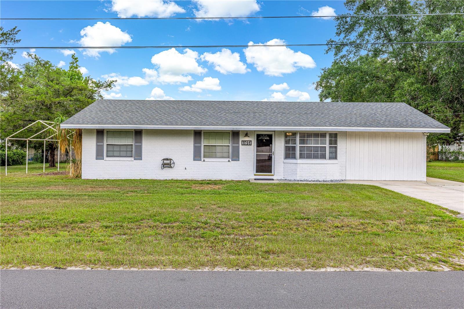 Under contract-accepting backup offers. Move-in ready and waiting for its new owners! This well-maintained 3-bedroom, 2-bath home offers over 1,465 square feet of heated and cooled living space with numerous updates and flexible living areas throughout.
The converted garage provides additional heated and cooled living space, ideal for a family room, home office, playroom, fitness area, or hobby room. The kitchen features stainless steel appliances, beautiful real wood cabinetry, and plenty of storage and workspace. Just off the kitchen, you’ll find a spacious family room with updated recessed lighting and brand-new carpet. Sliding glass doors lead to the enclosed screened porch, creating the perfect space for enjoying Florida’s indoor-outdoor lifestyle. A large rear patio offers plenty of room for entertaining, grilling, and family gatherings. Recent improvements include a new roof in 2021, newer A/C system, newer water heater, fresh interior paint, new carpeting in the bedrooms and family room, and attractive wood-look tile flooring in the main living area.
Situated on a generous 0.43-acre lot, the property also features a large 14’ x 24’ shed with electricity, making it an excellent workshop, storage area, or space for your favorite hobbies. With immediate occupancy available, this home is ready for you to move in and start making memories